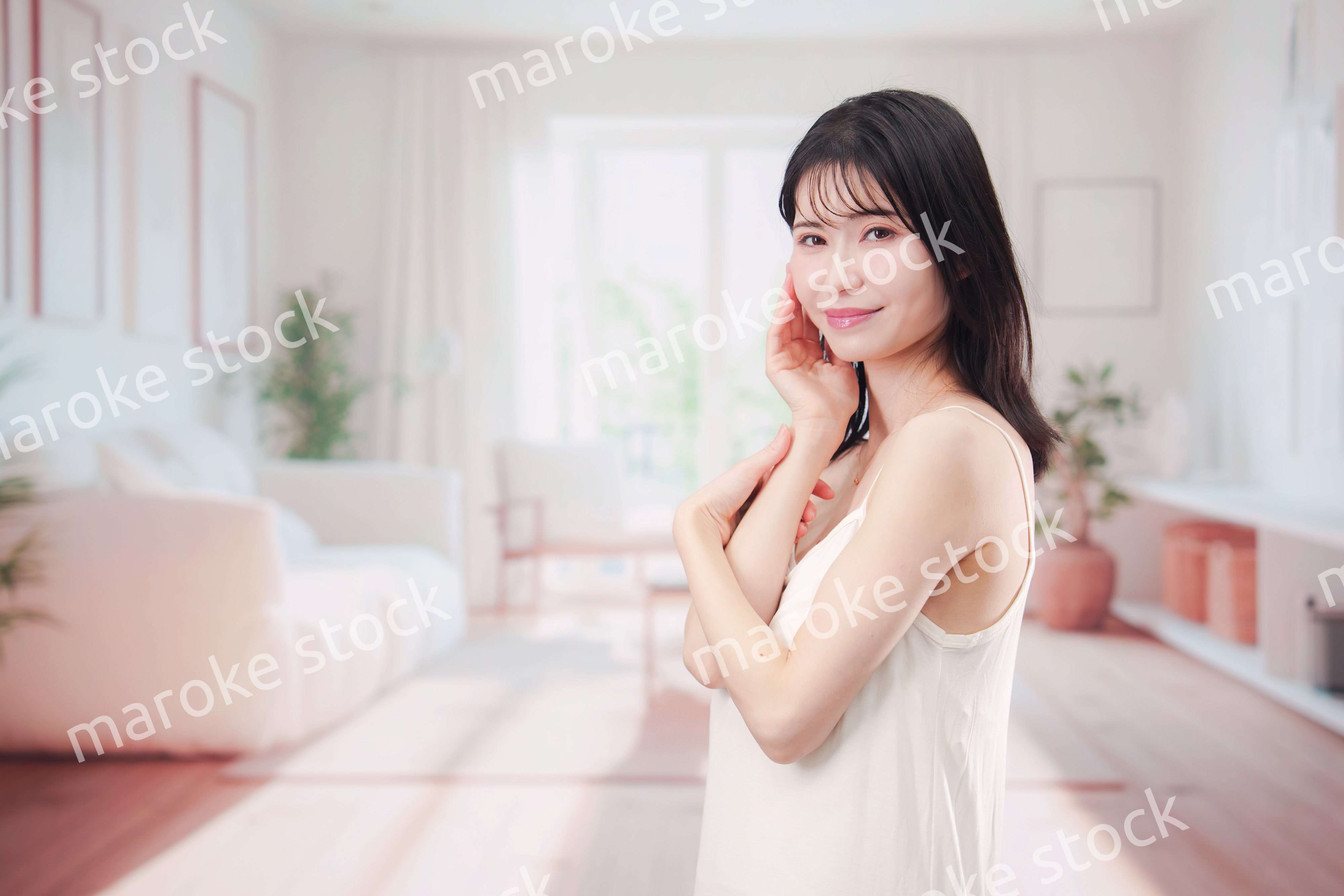 部屋でビューティケアをする若い女性