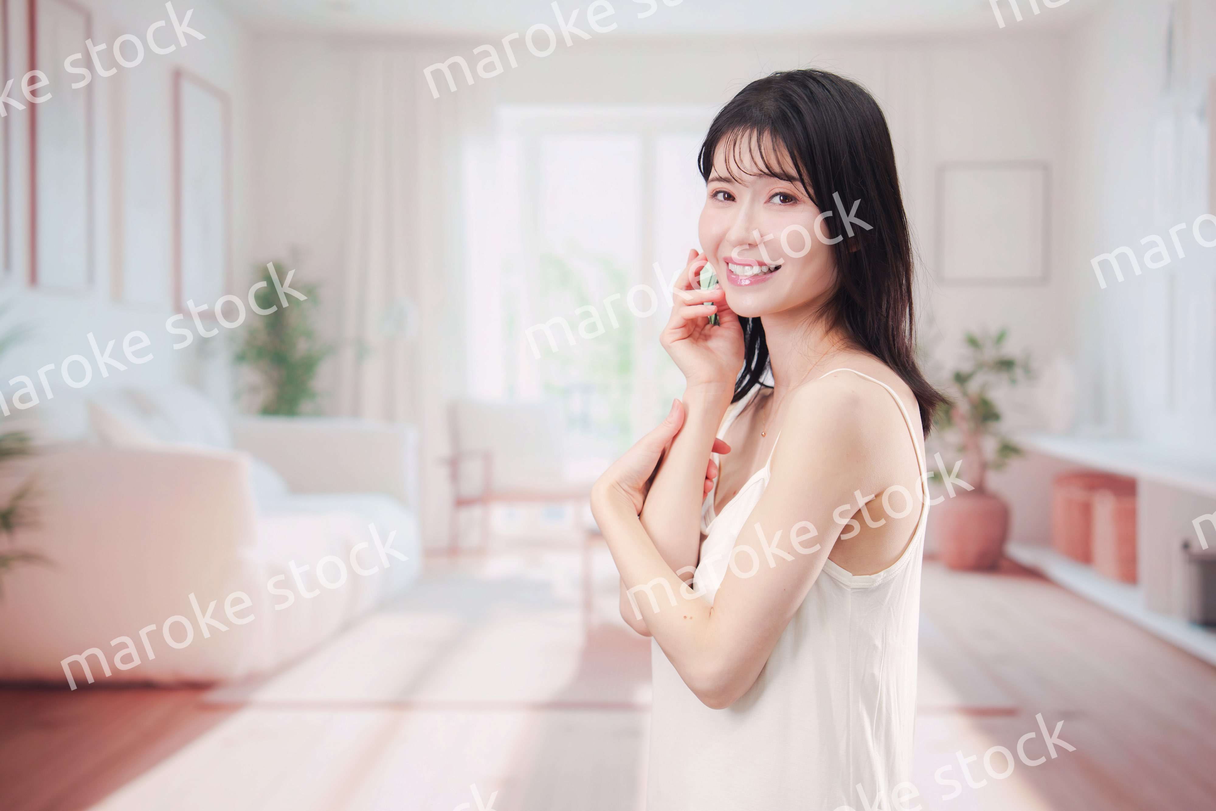 部屋でビューティケアをする若い女性