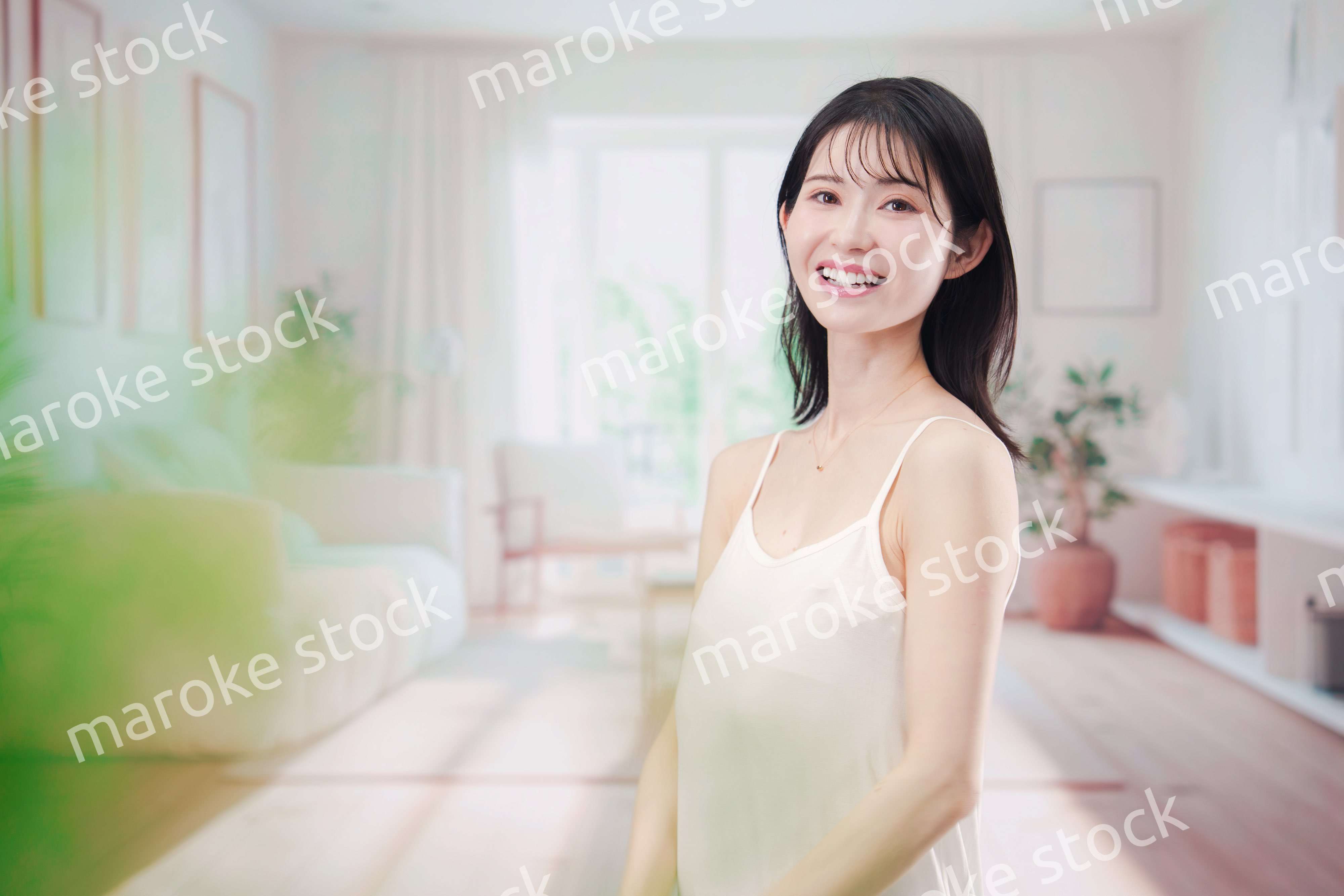 部屋でスキンケアをする若い女性