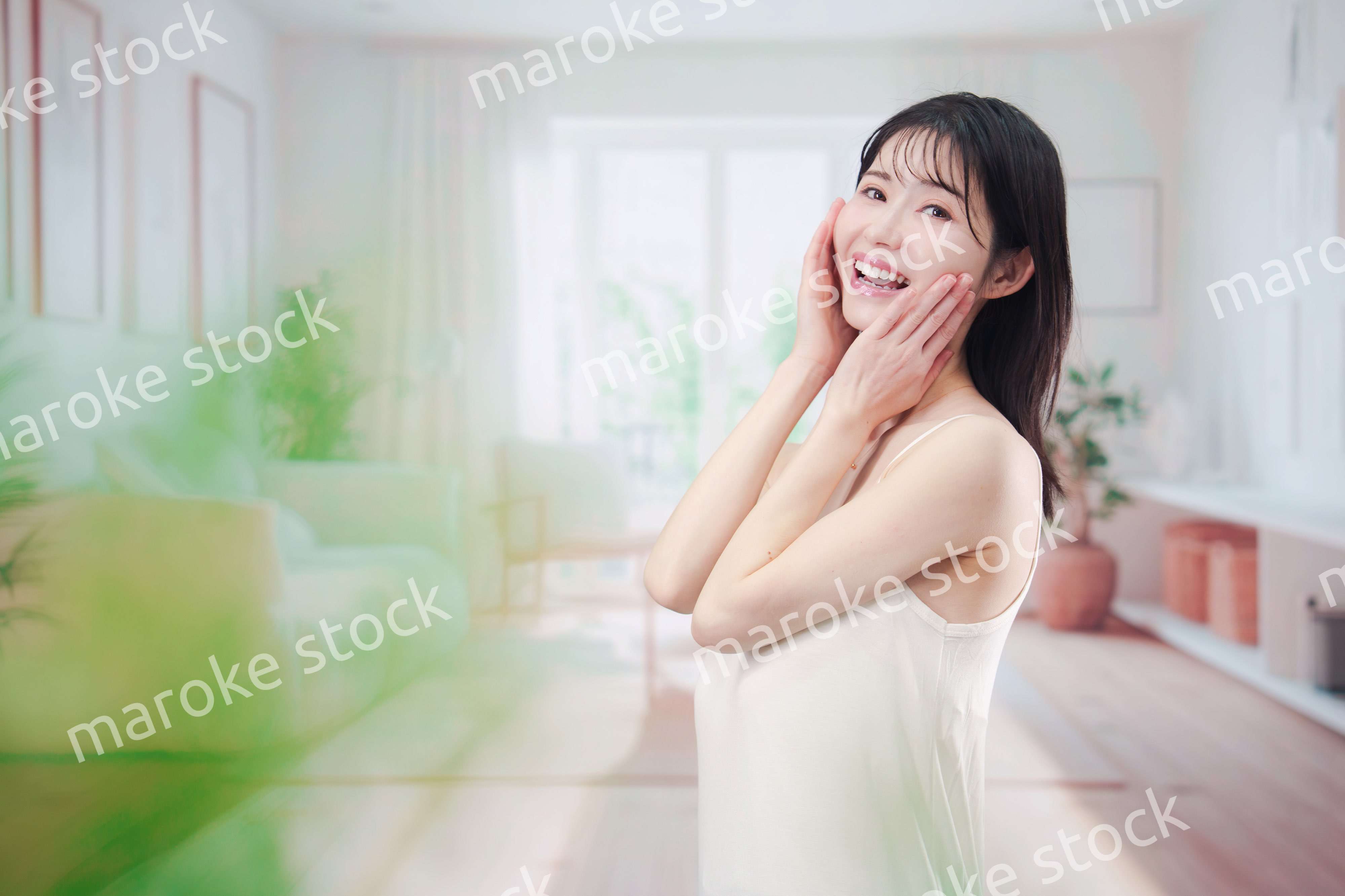 部屋でスキンケアをする若い女性