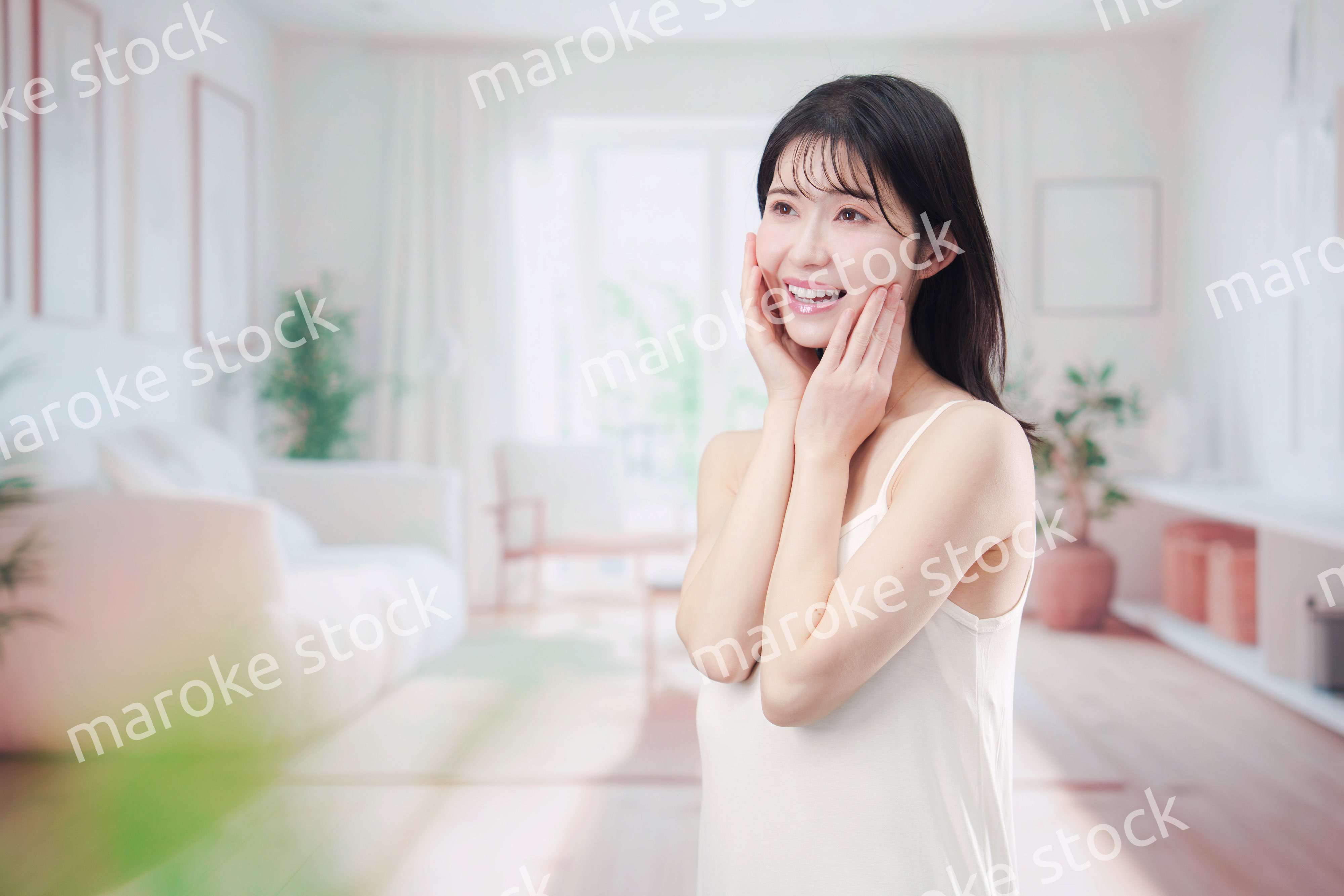 部屋でスキンケアをする若い女性