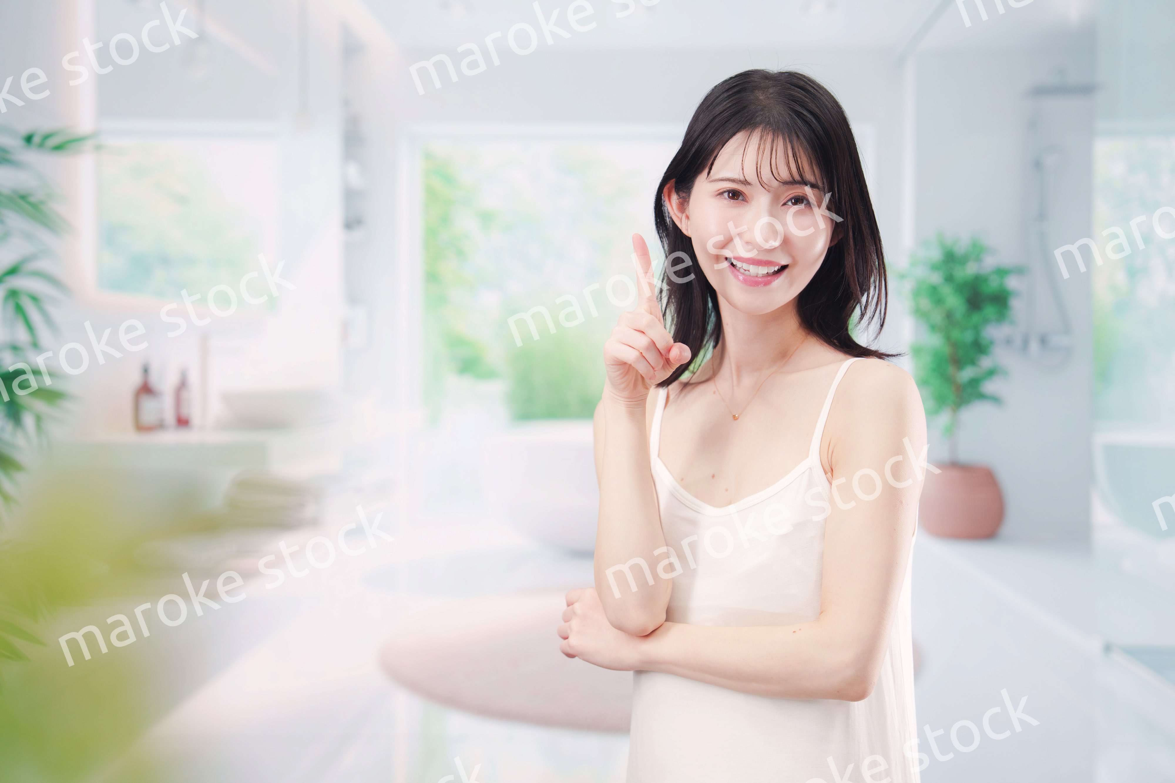 バスルームでスキンケアをする若い女性