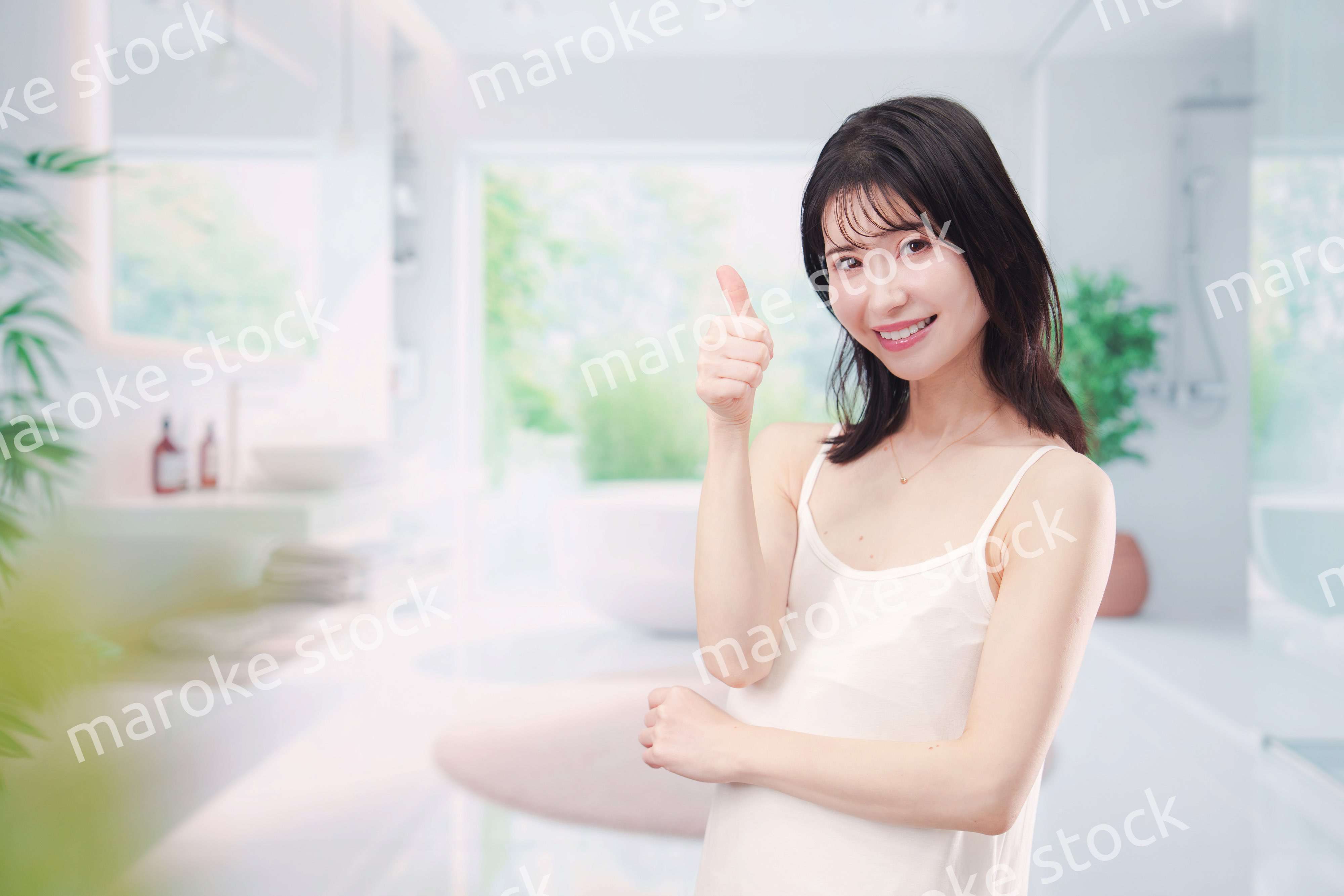 バスルームでスキンケアをする若い女性