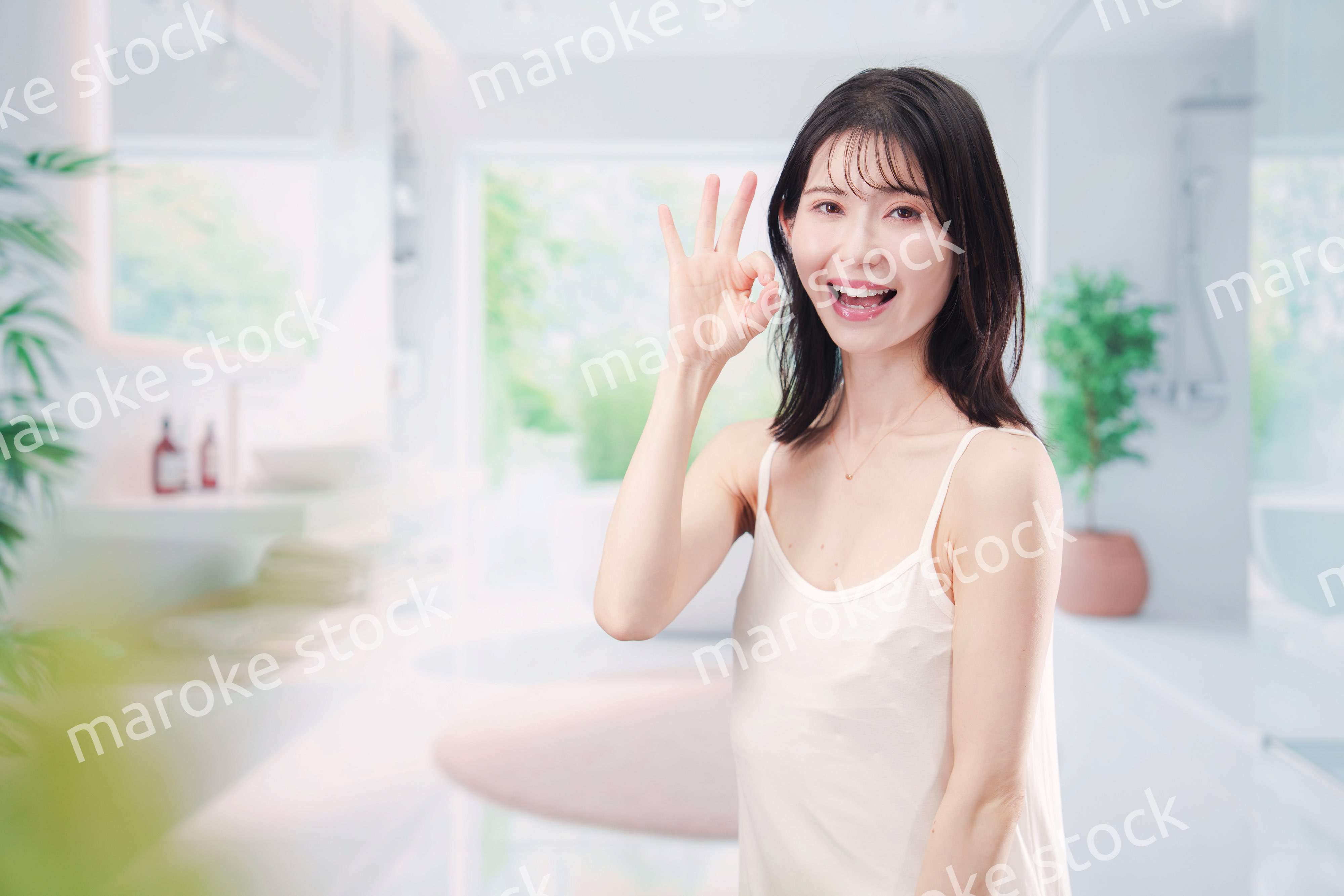 バスルームでスキンケアをする若い女性