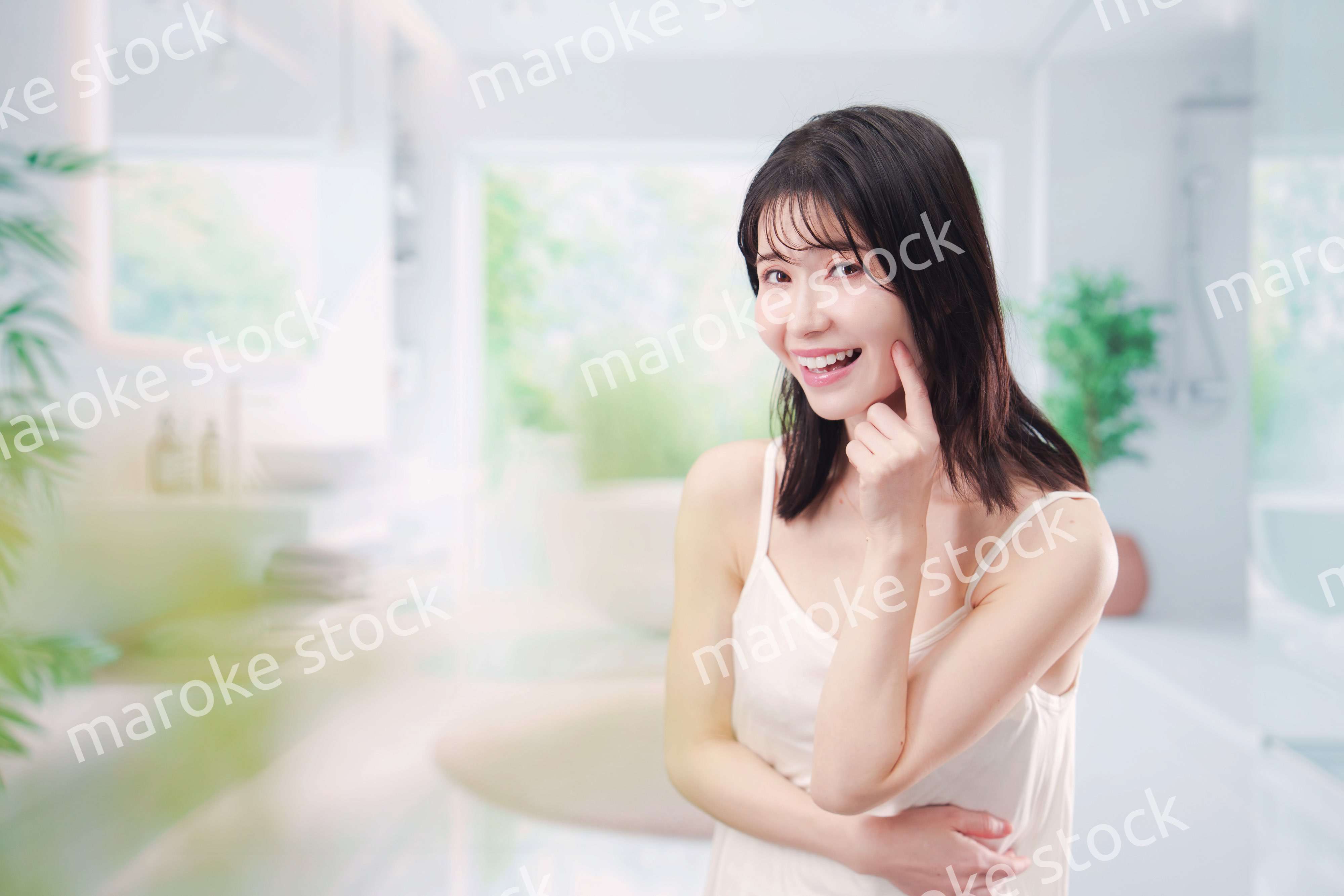 バスルームでスキンケアをする若い女性