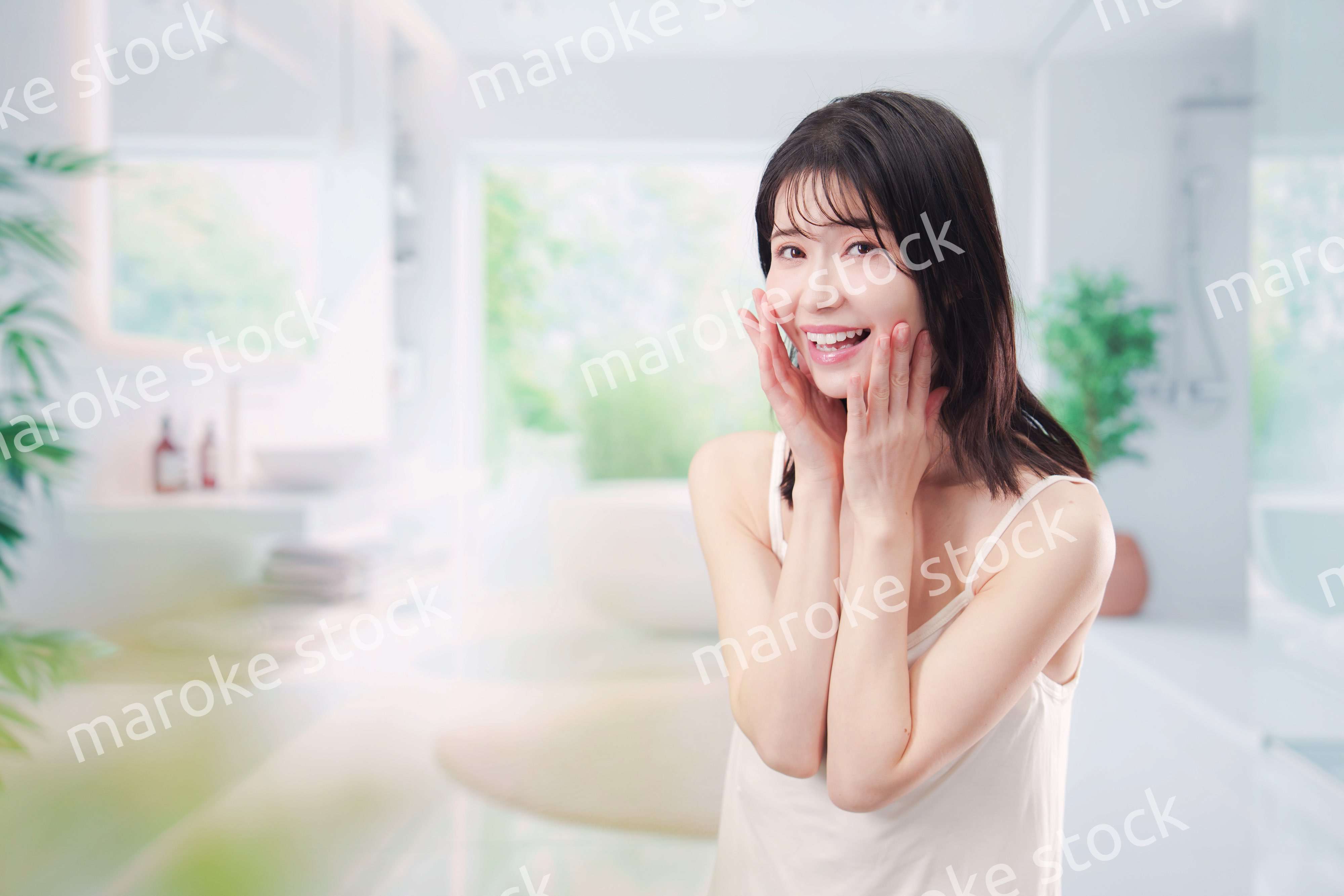 バスルームでスキンケアをする若い女性