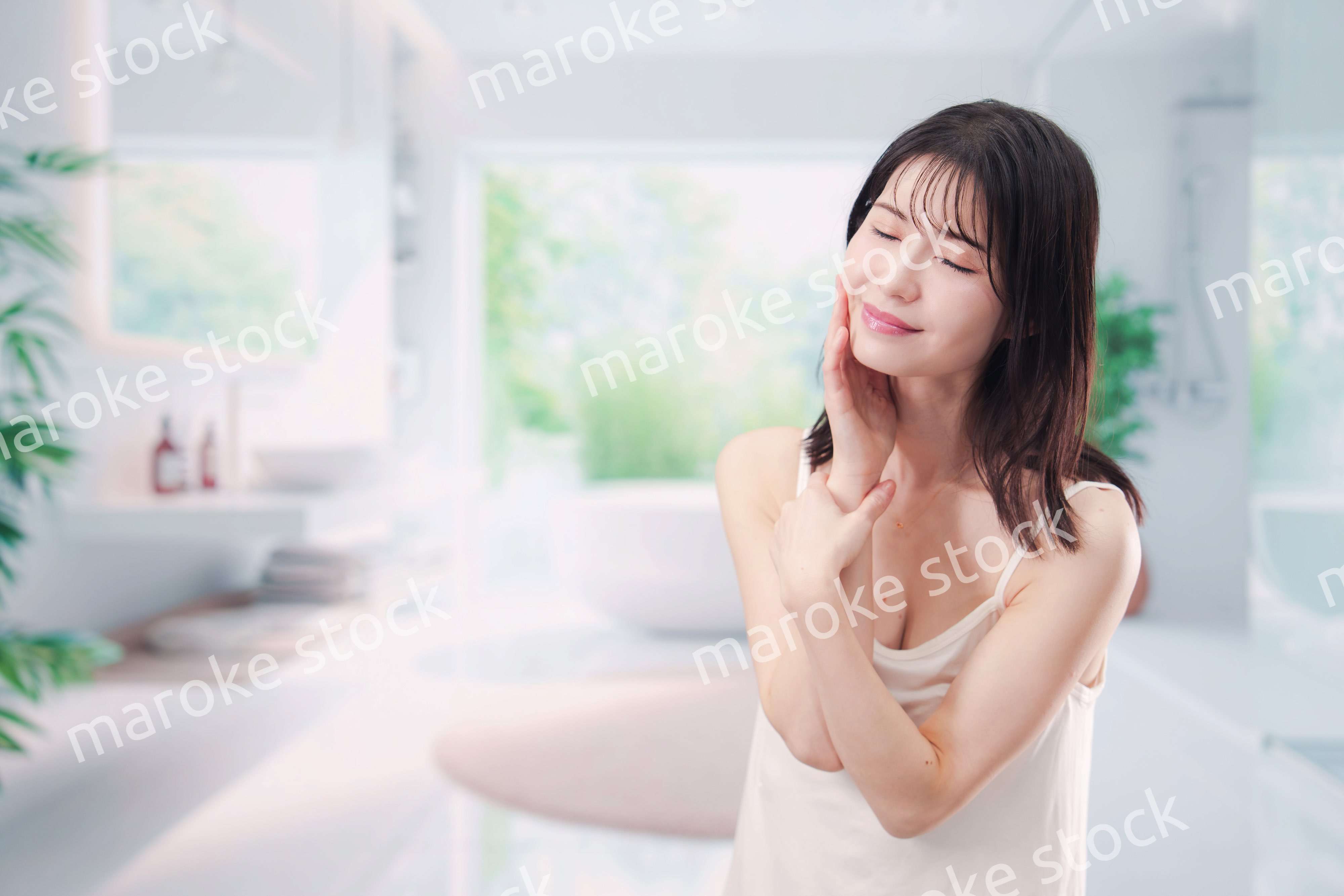 バスルームでスキンケアをする若い女性