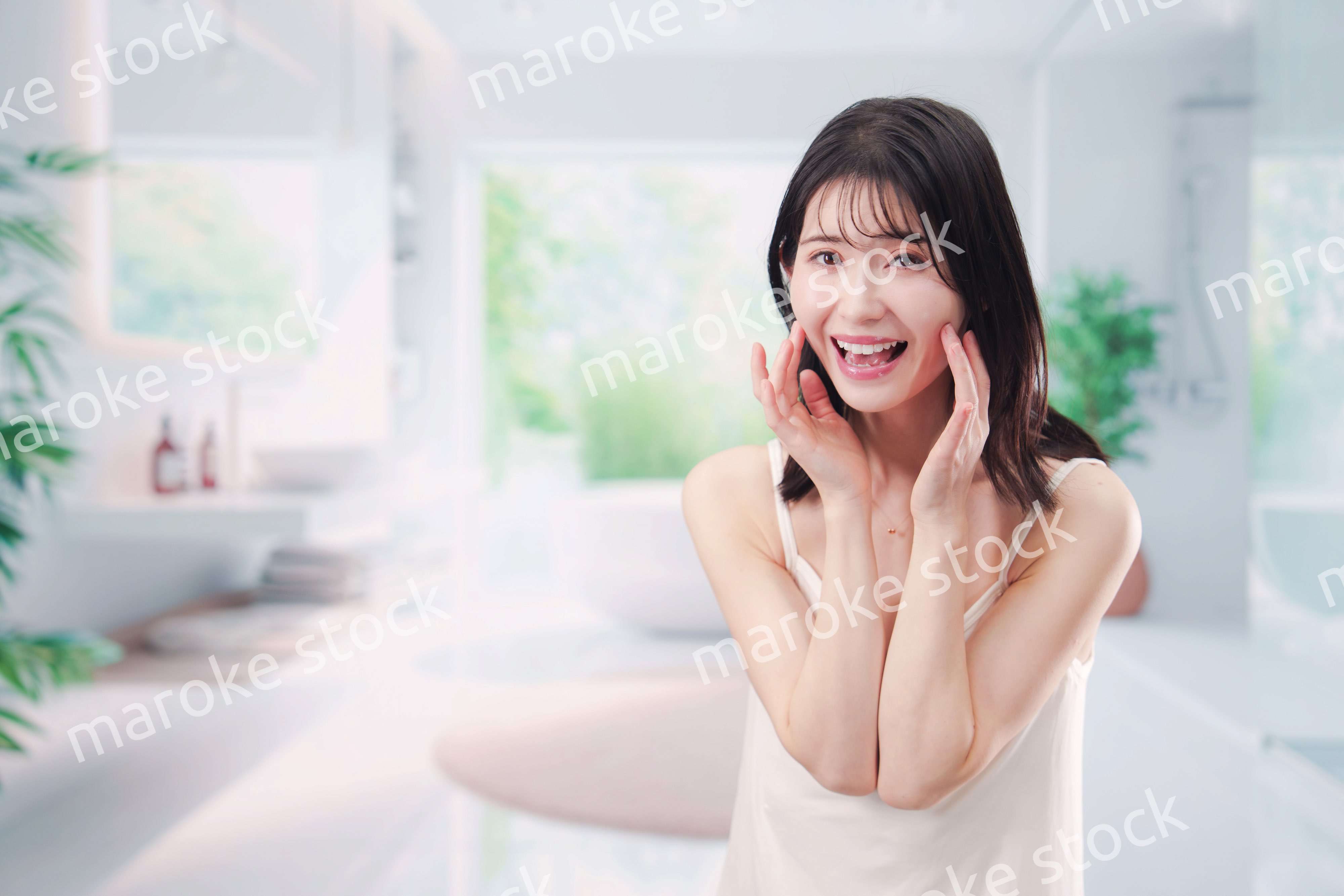 バスルームでスキンケアをする若い女性