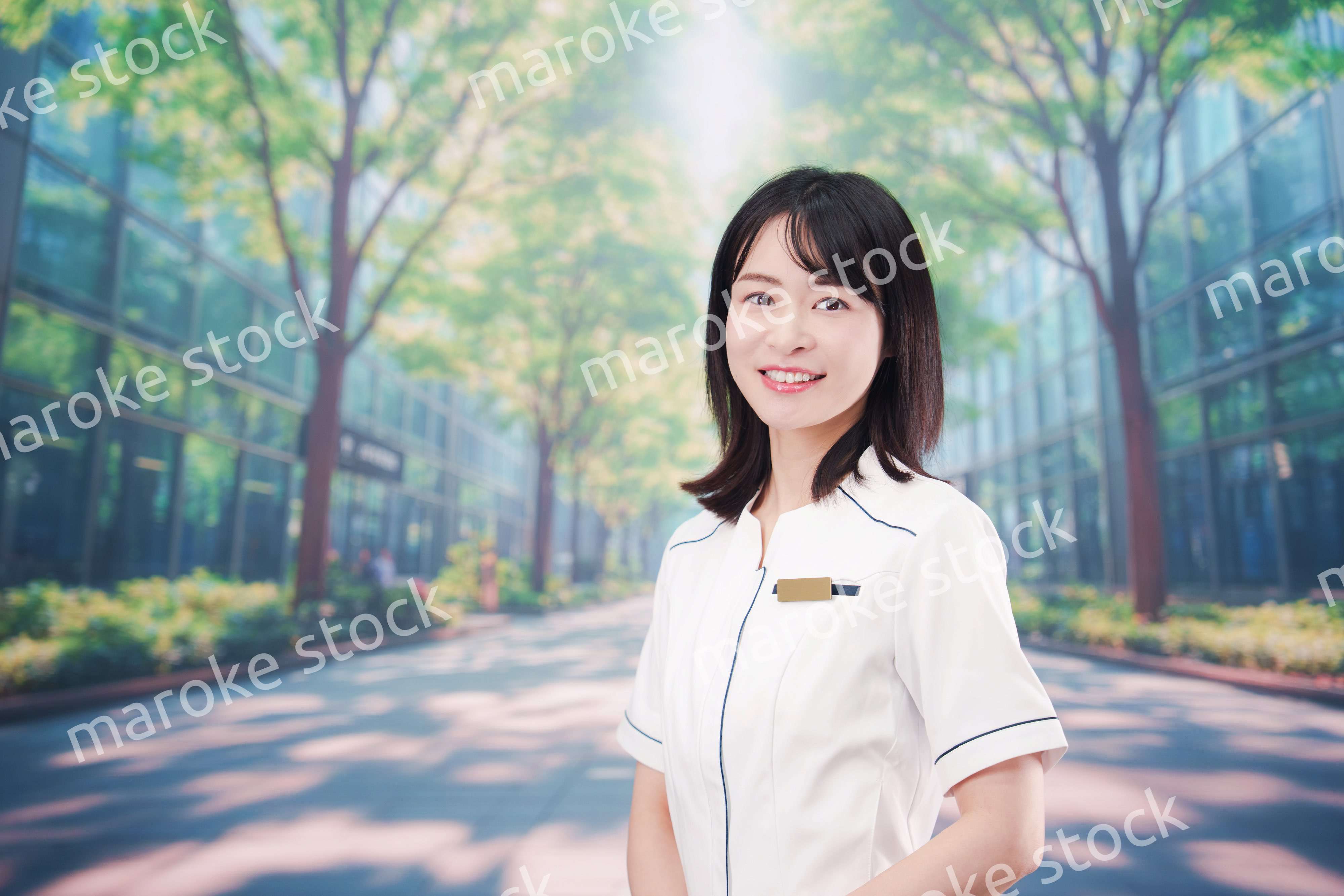 白衣を着て笑顔で外を歩く医療従事者の若い女性