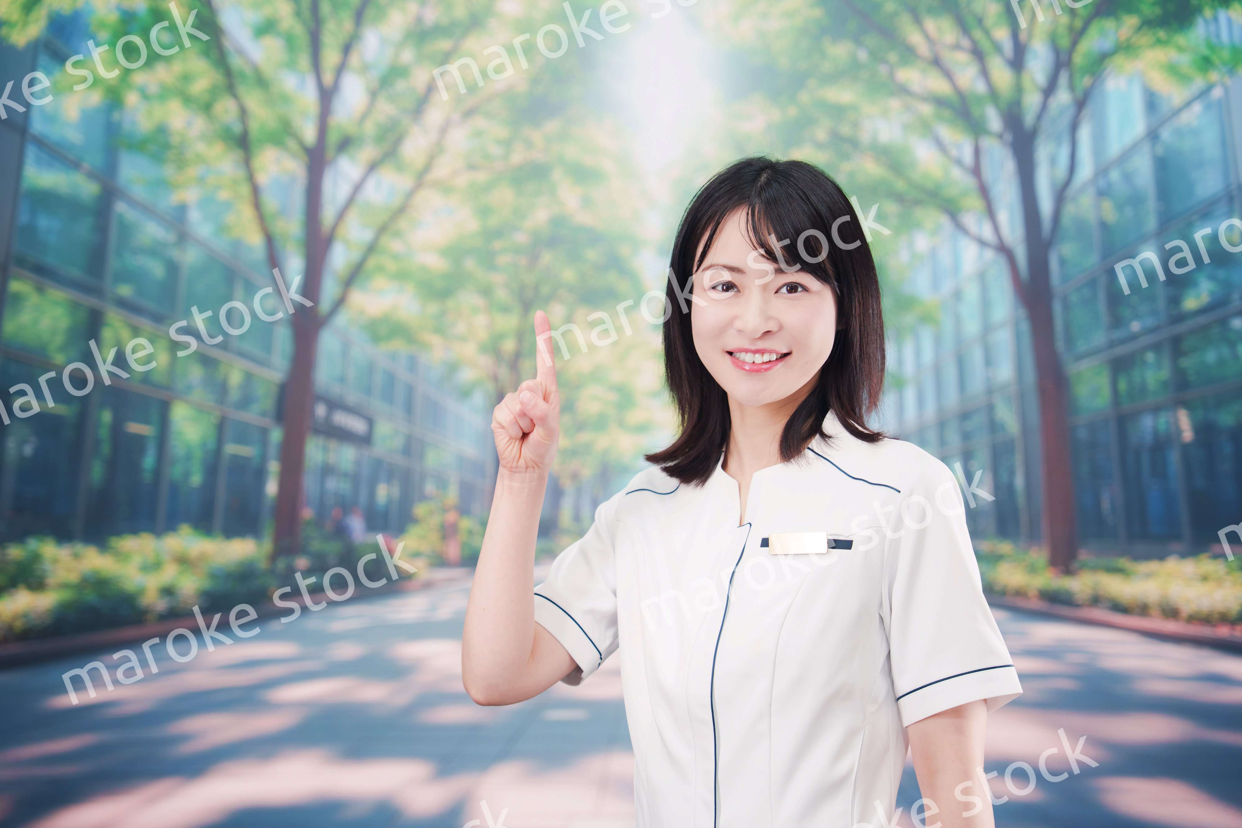 白衣を着て笑顔で外を歩く医療従事者の若い女性