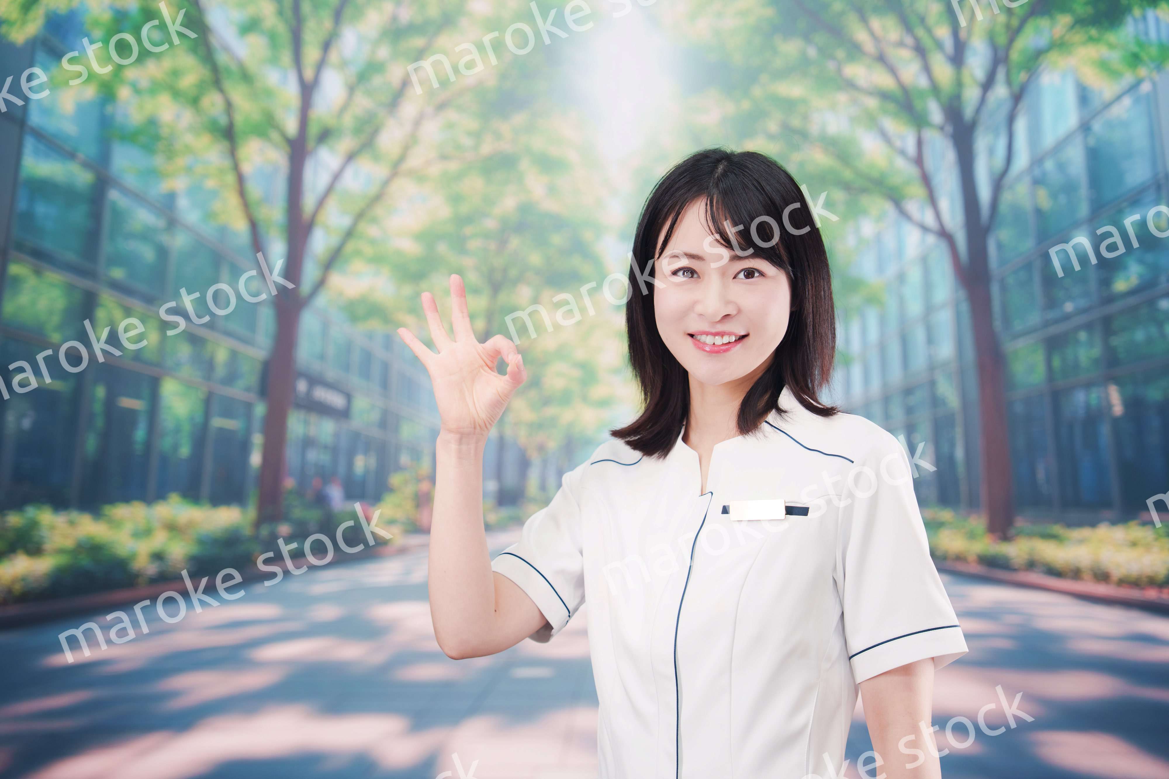 白衣を着て笑顔で外を歩く医療従事者の若い女性