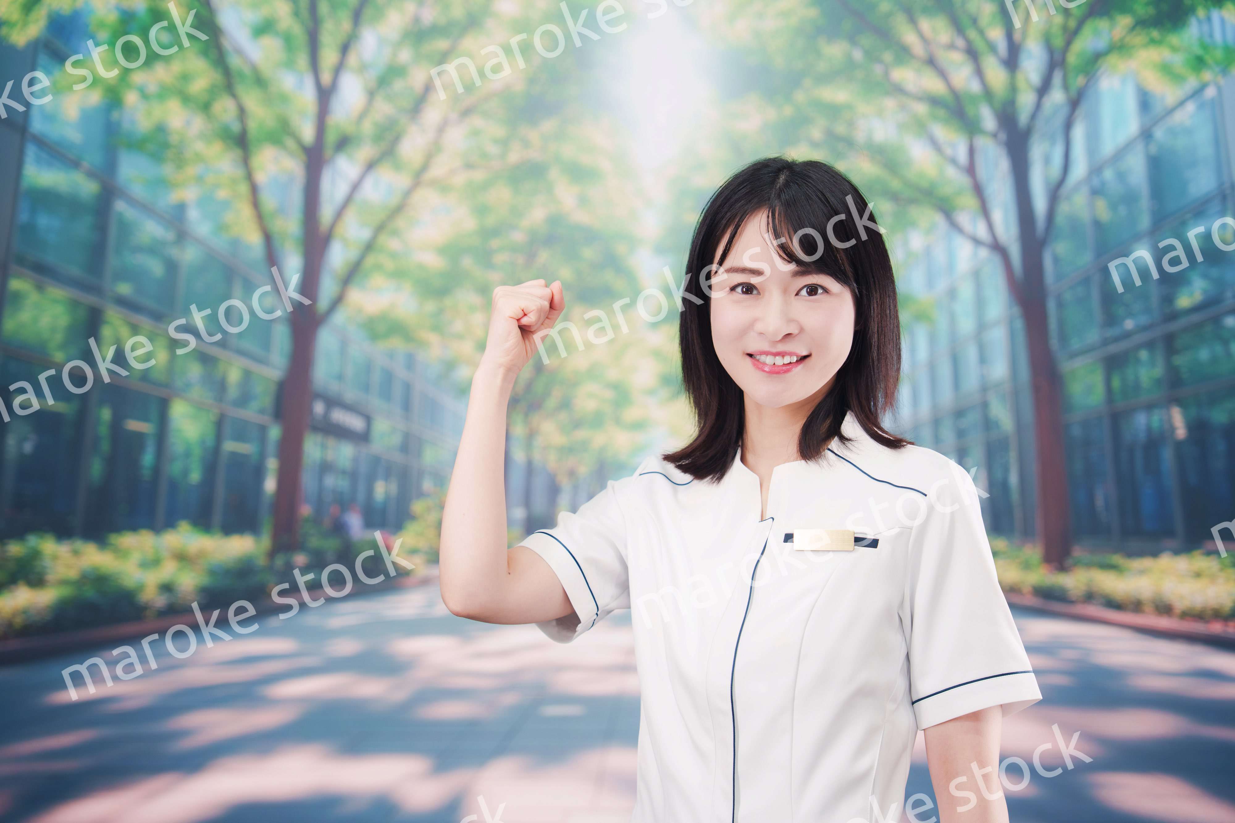 白衣を着て笑顔で外を歩く医療従事者の若い女性