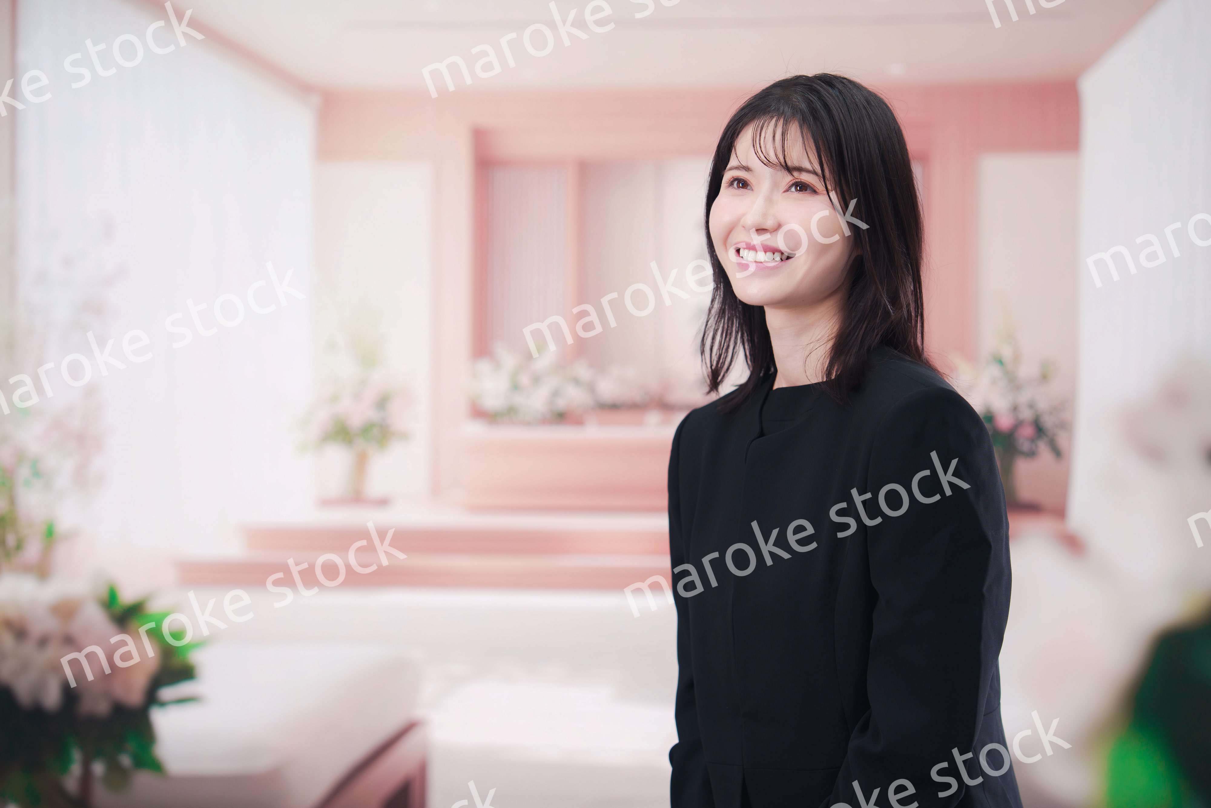 お葬式で喪服を着て数珠を持つ若い女性