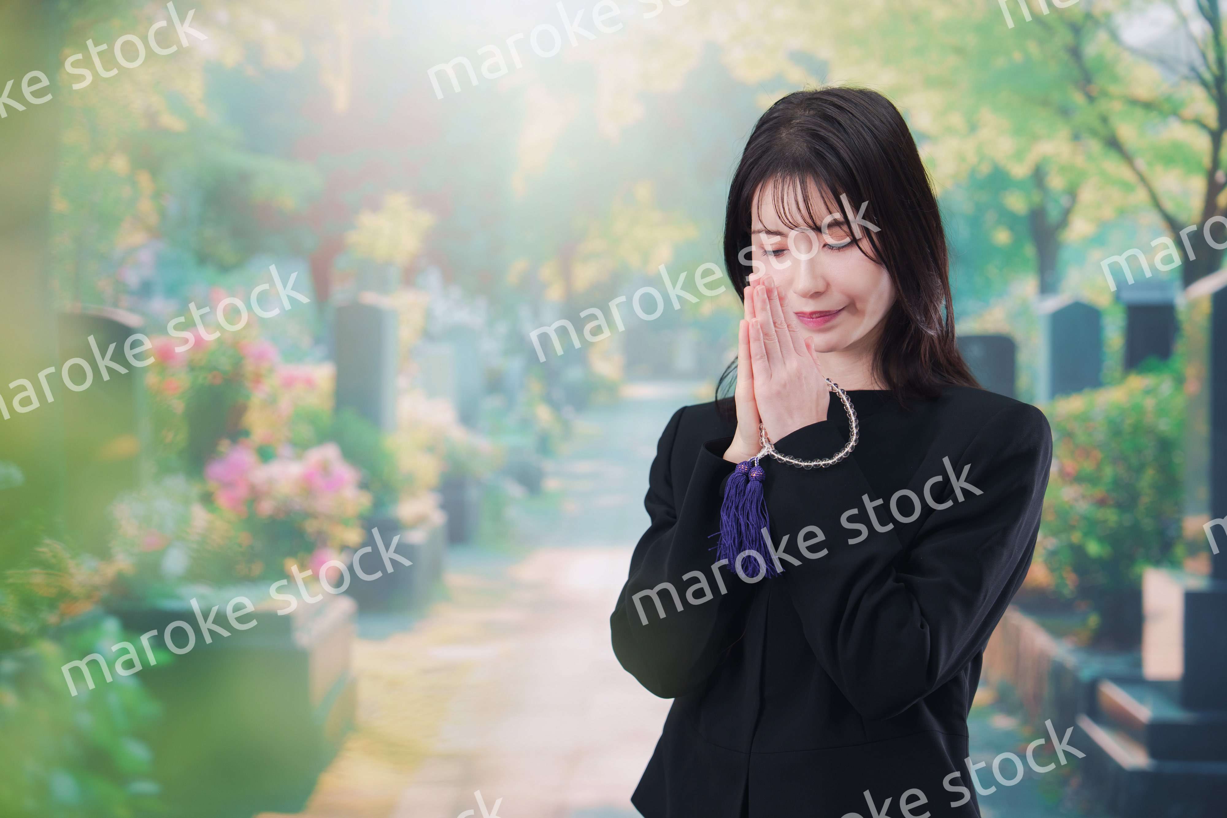 喪服を着てお墓参りをする女性