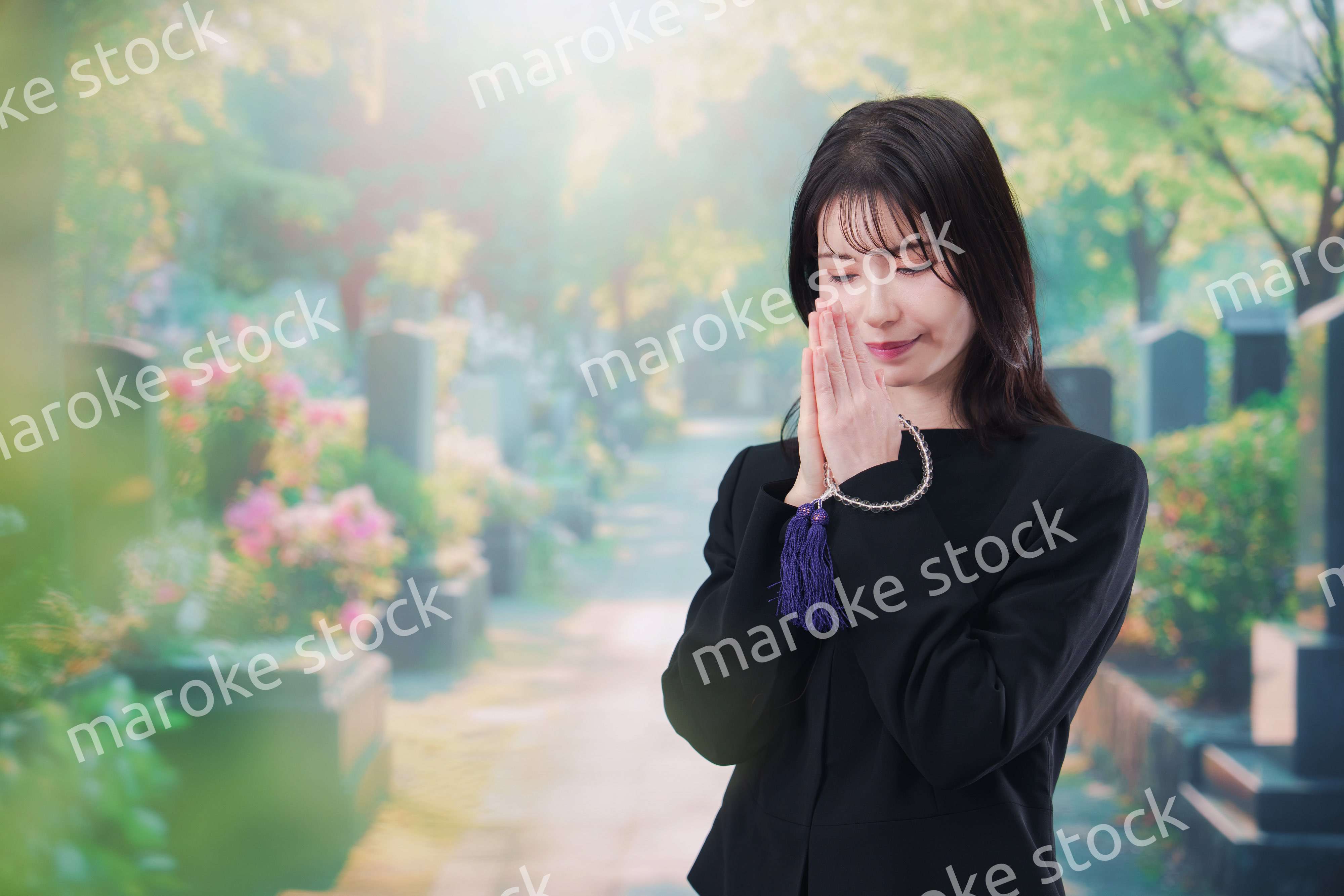 喪服を着てお墓参りをする女性