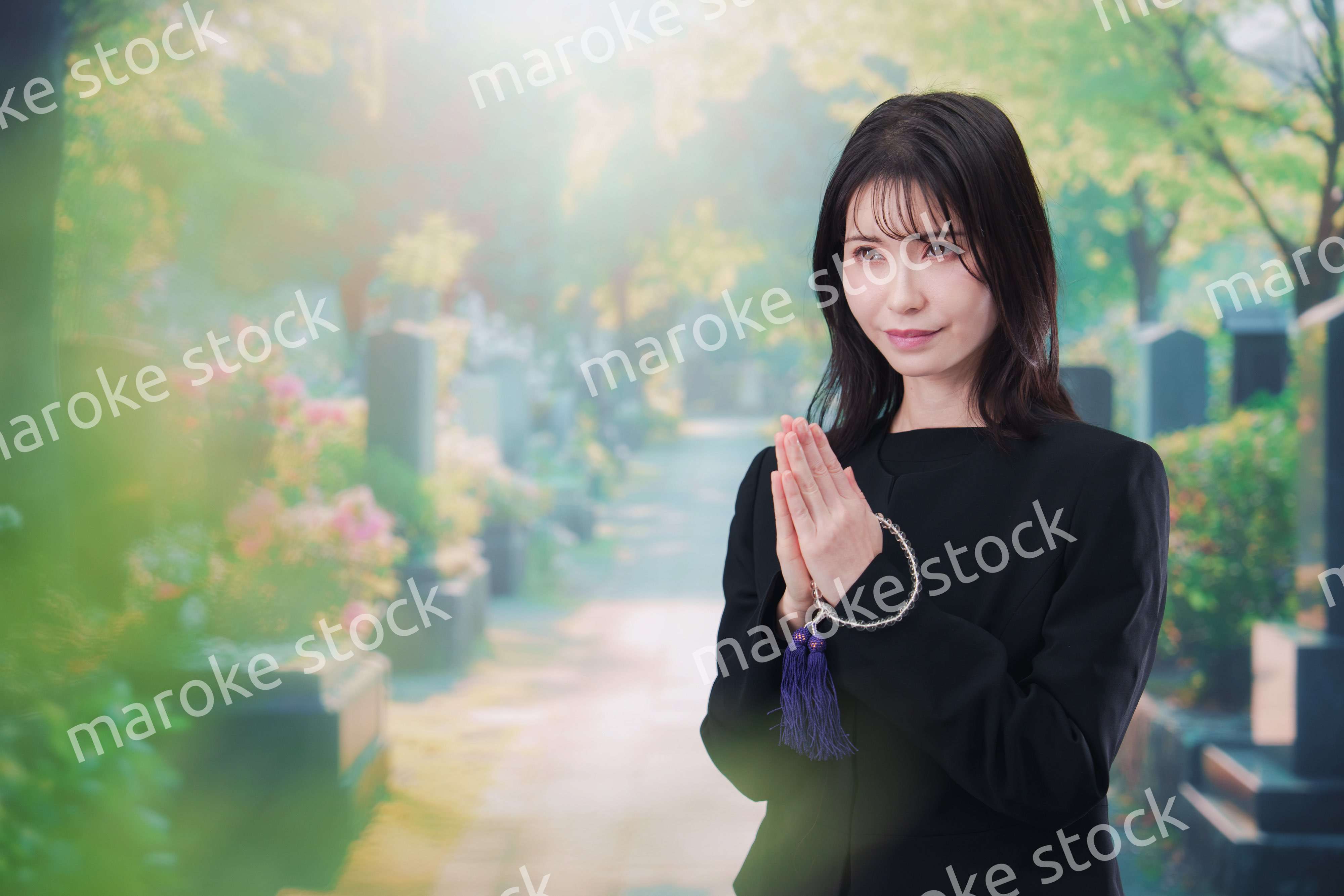 喪服を着てお墓参りをする女性