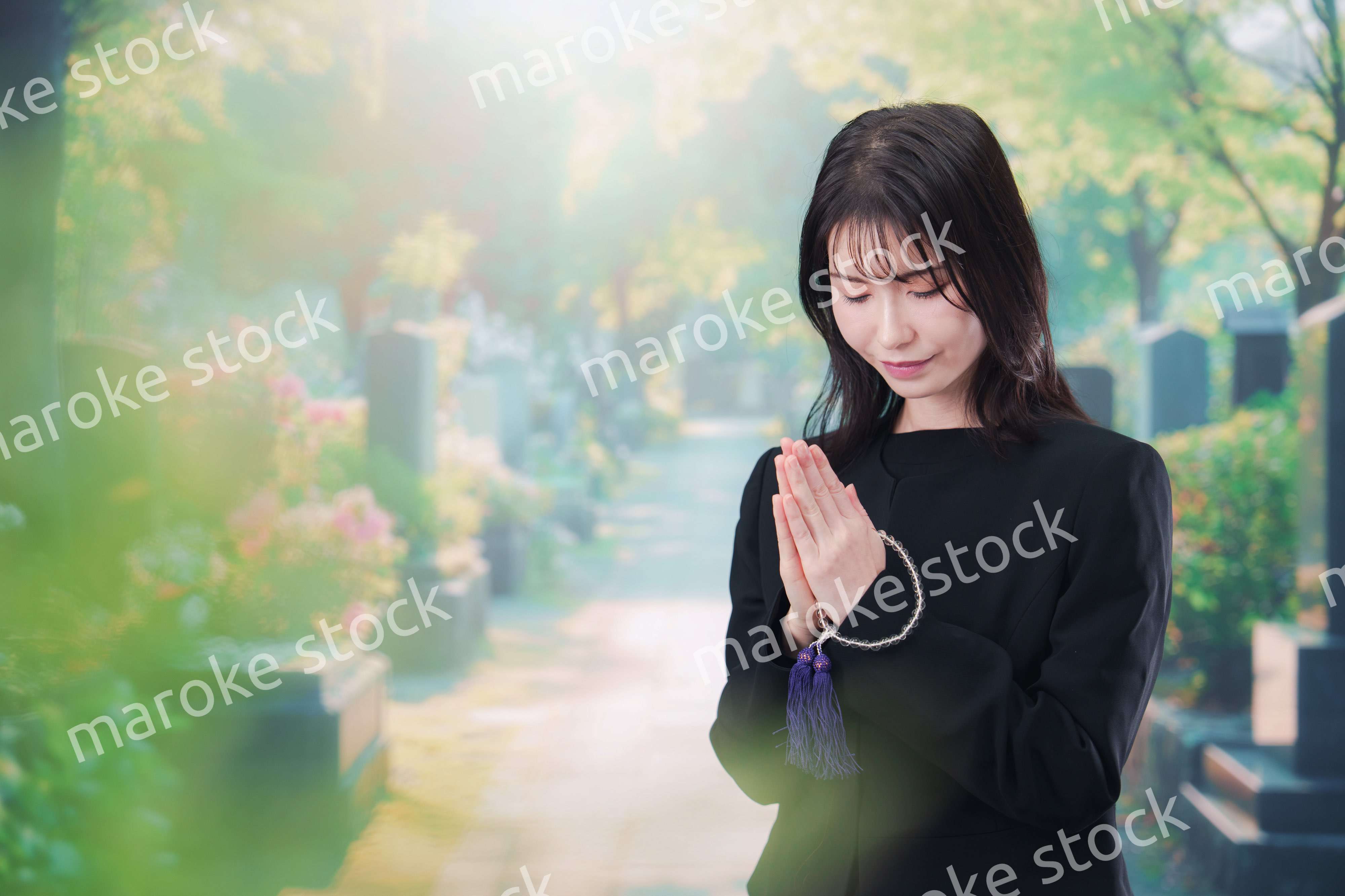 喪服を着てお墓参りをする女性