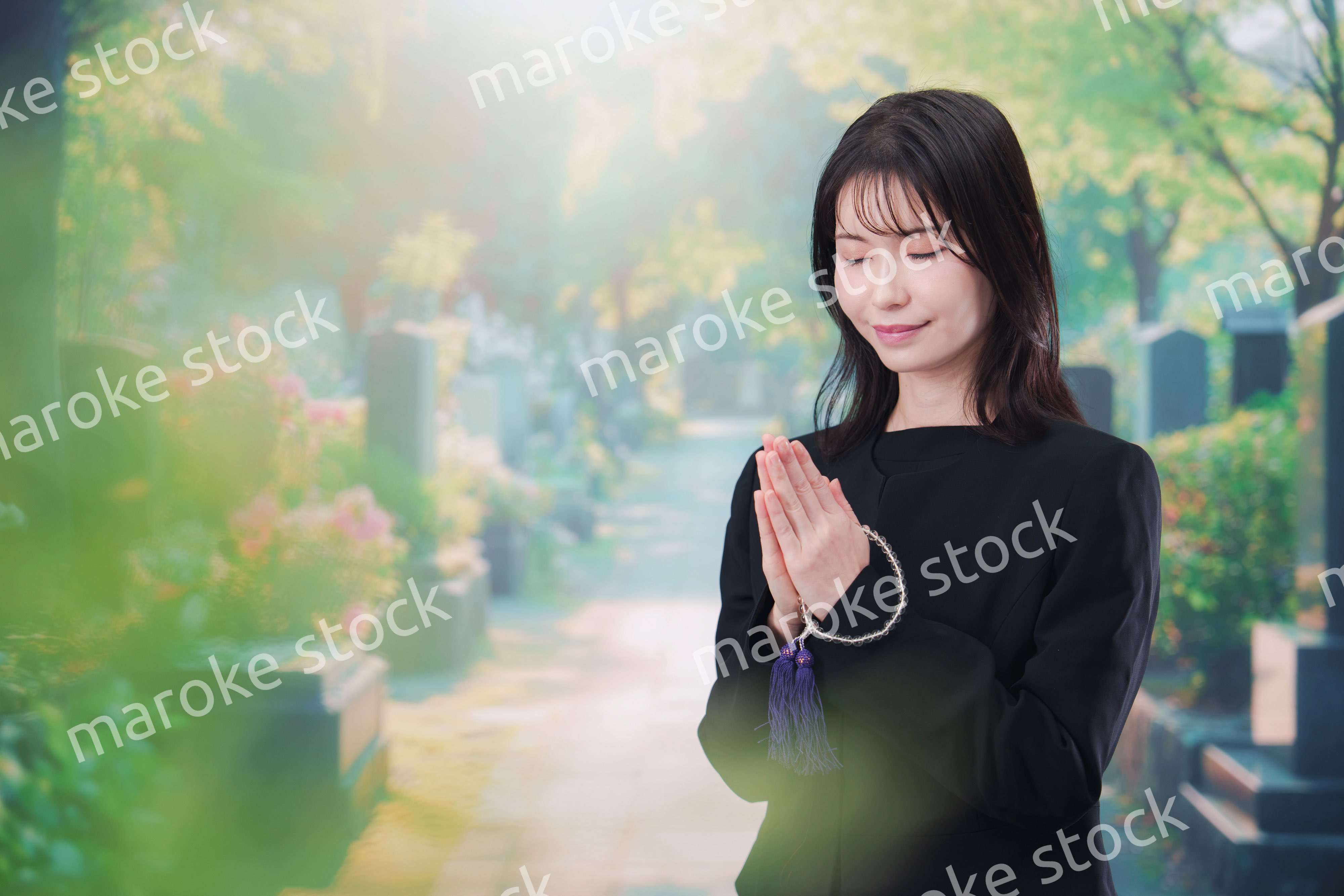 喪服を着てお墓参りをする女性