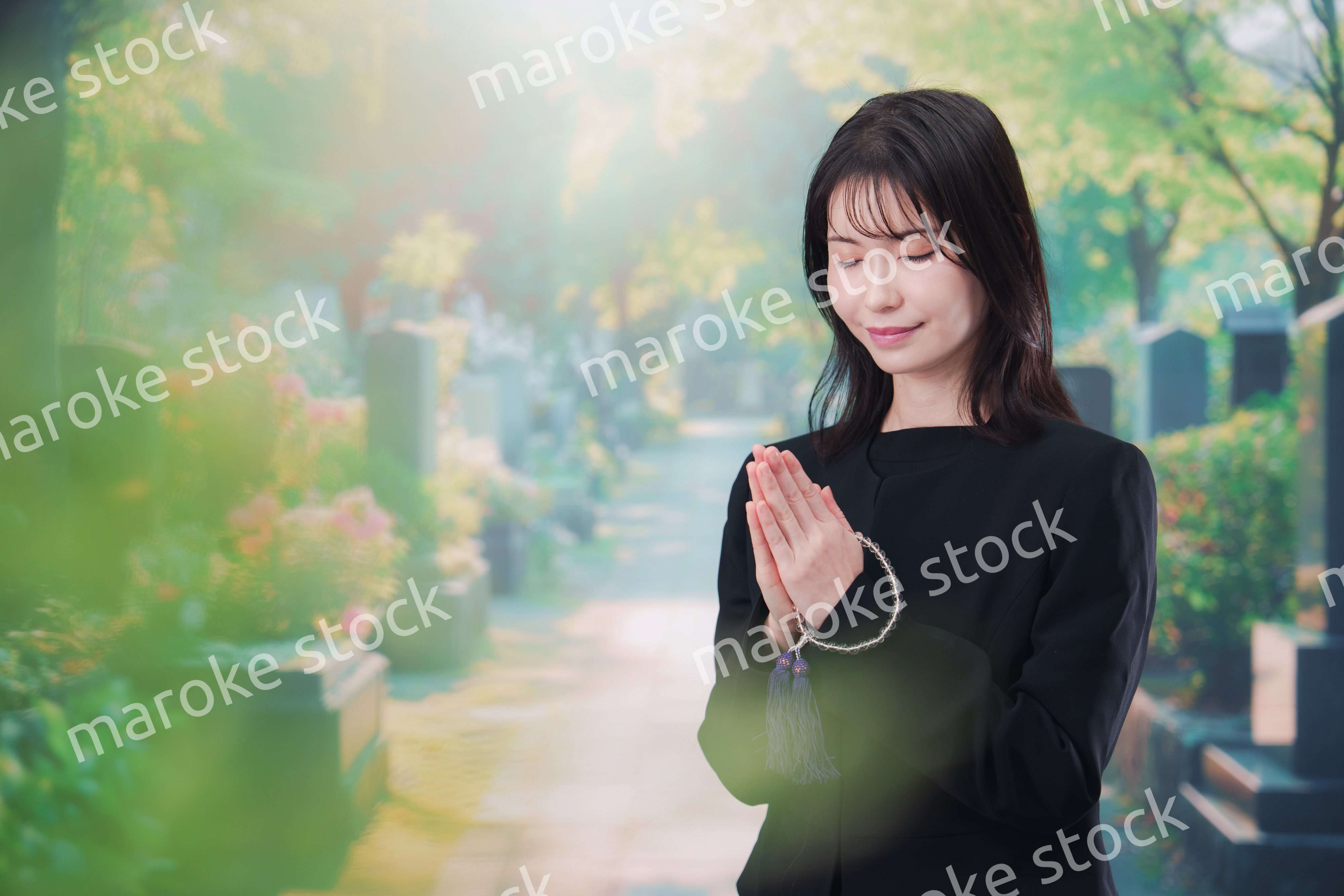 喪服を着てお墓参りをする女性