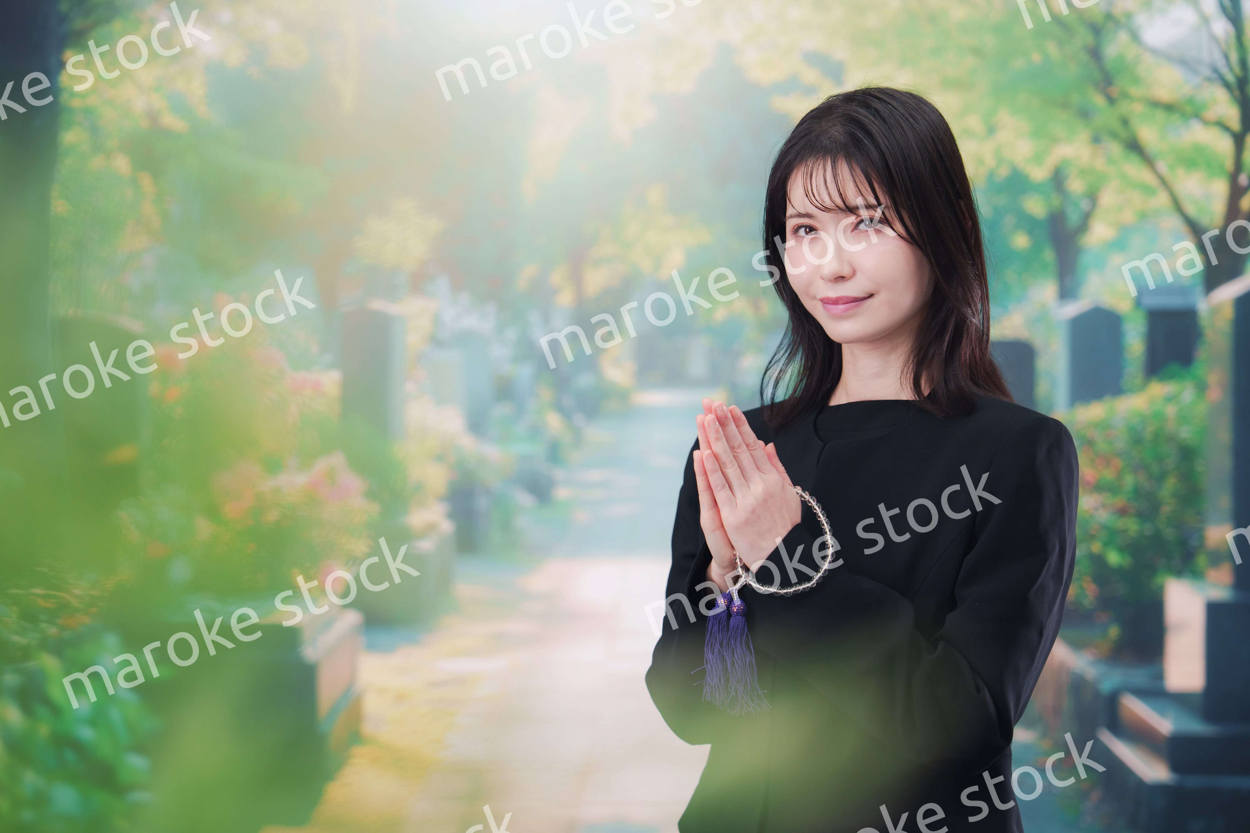 喪服を着てお墓参りをする女性