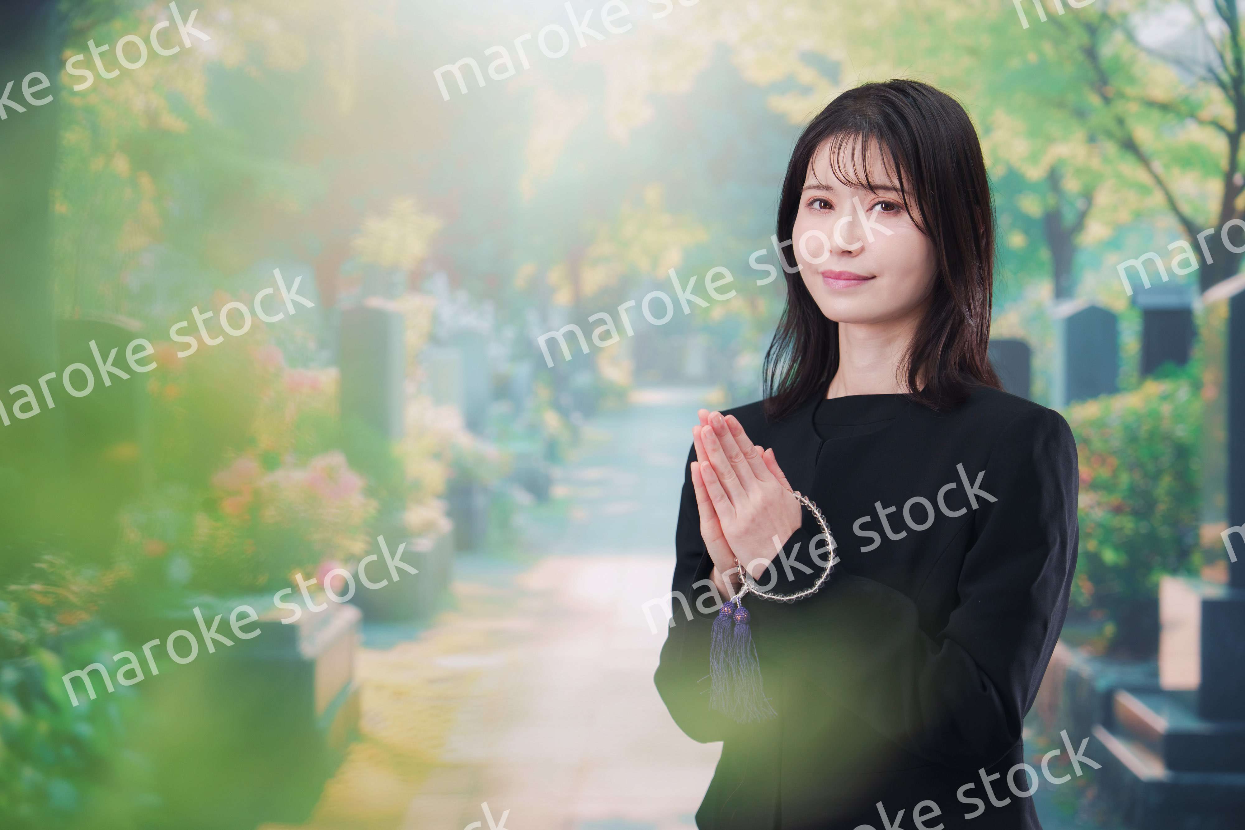 喪服を着てお墓参りをする女性