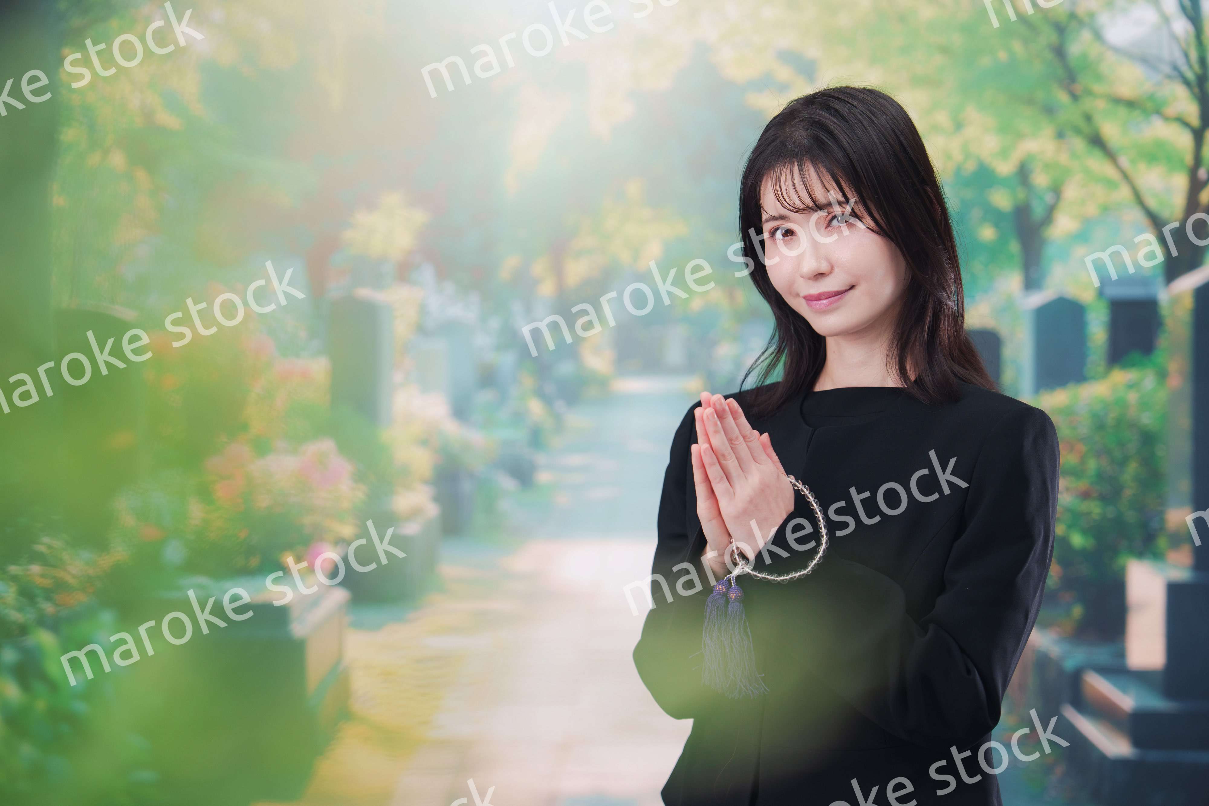 喪服を着てお墓参りをする女性