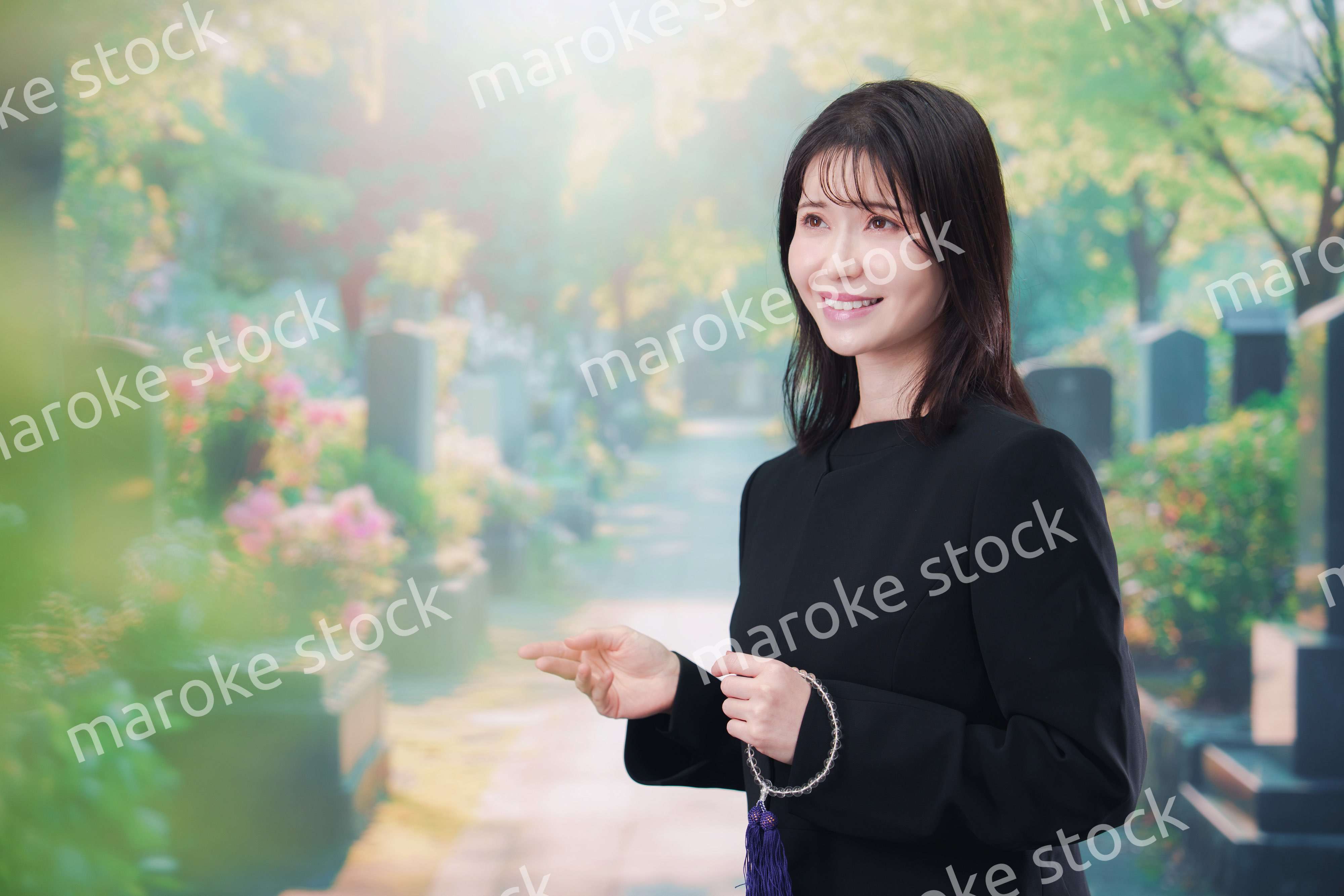 喪服を着てお墓参りをする女性