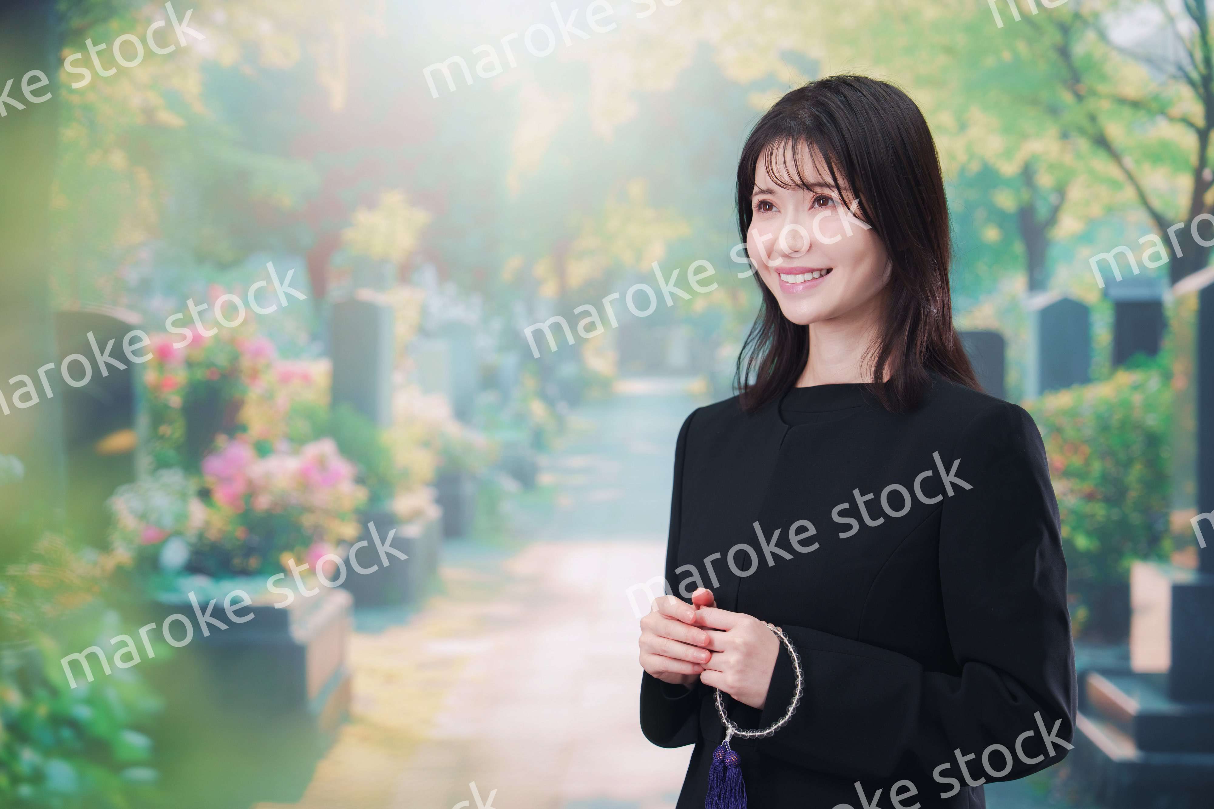 喪服を着てお墓参りをする女性