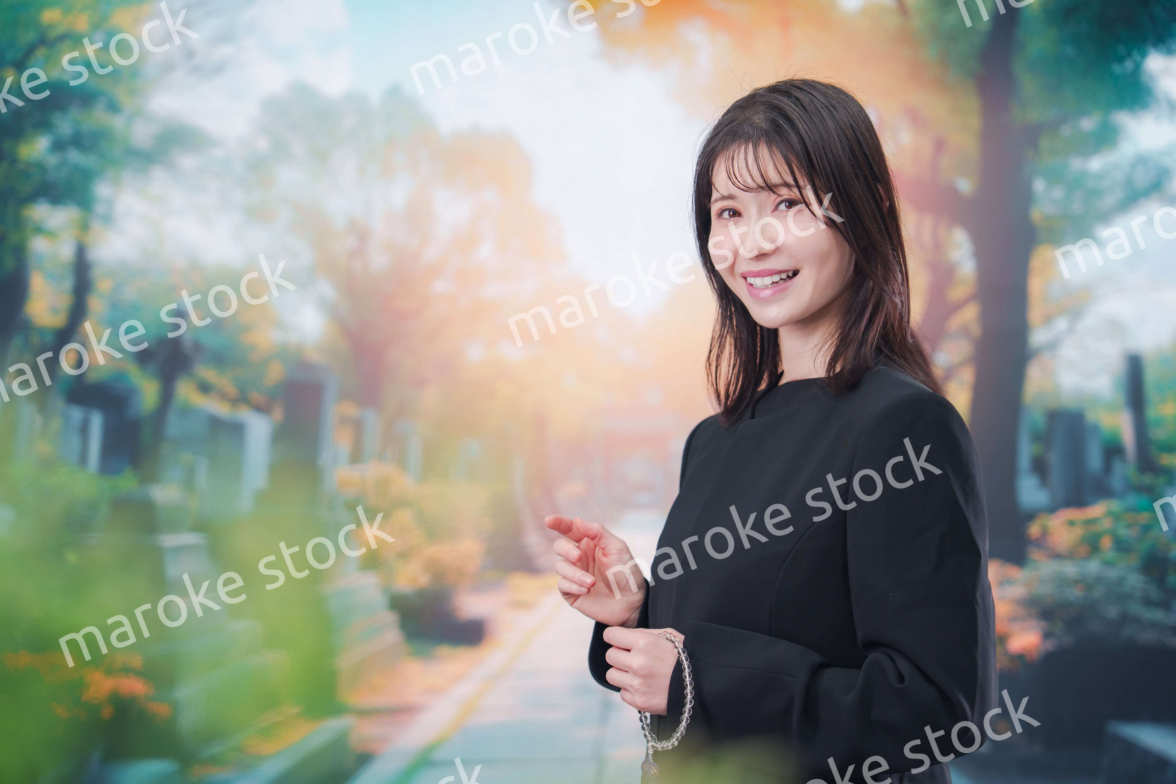 喪服を着てお墓参りをする女性