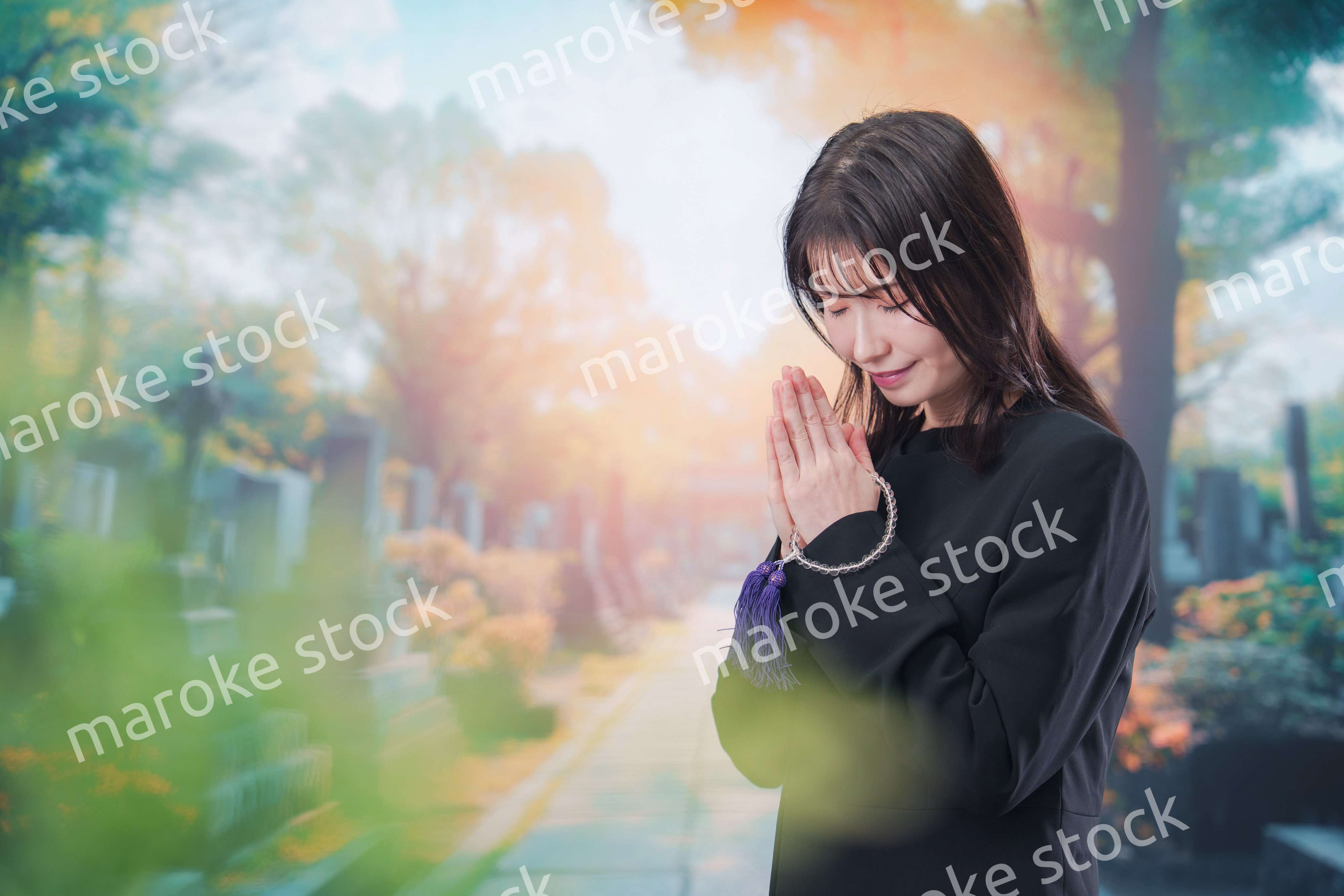 喪服を着てお墓参りをする女性