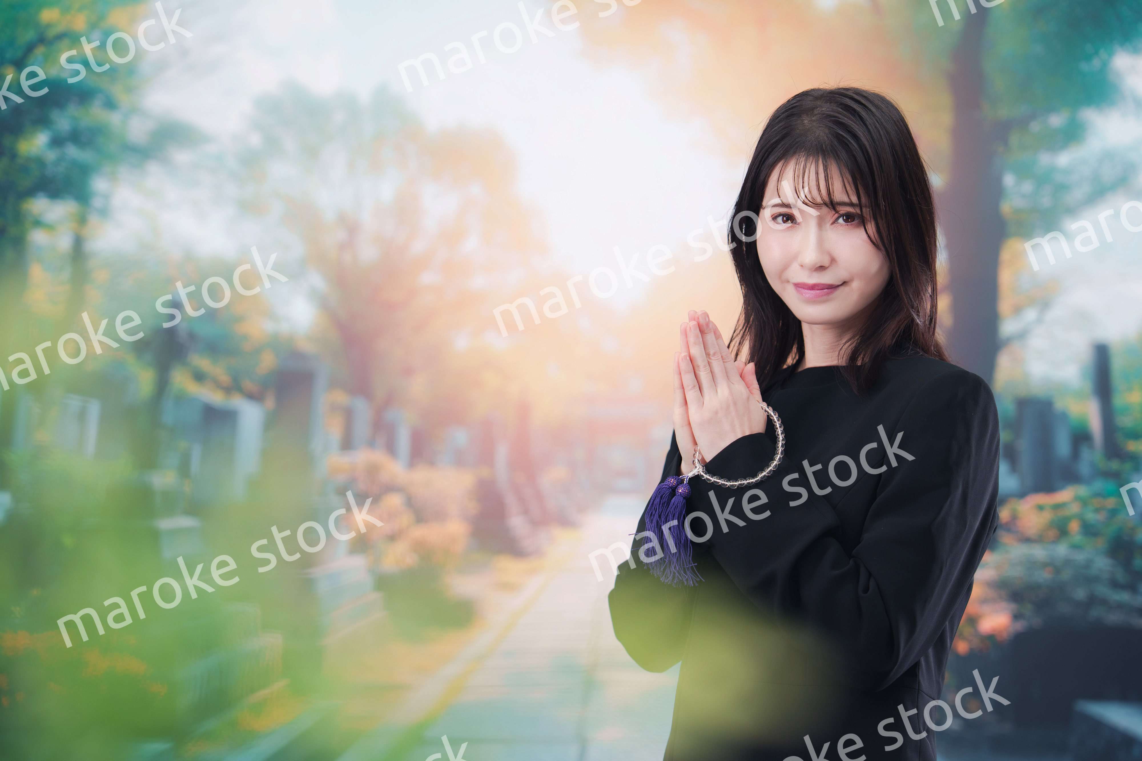 喪服を着てお墓参りをする女性