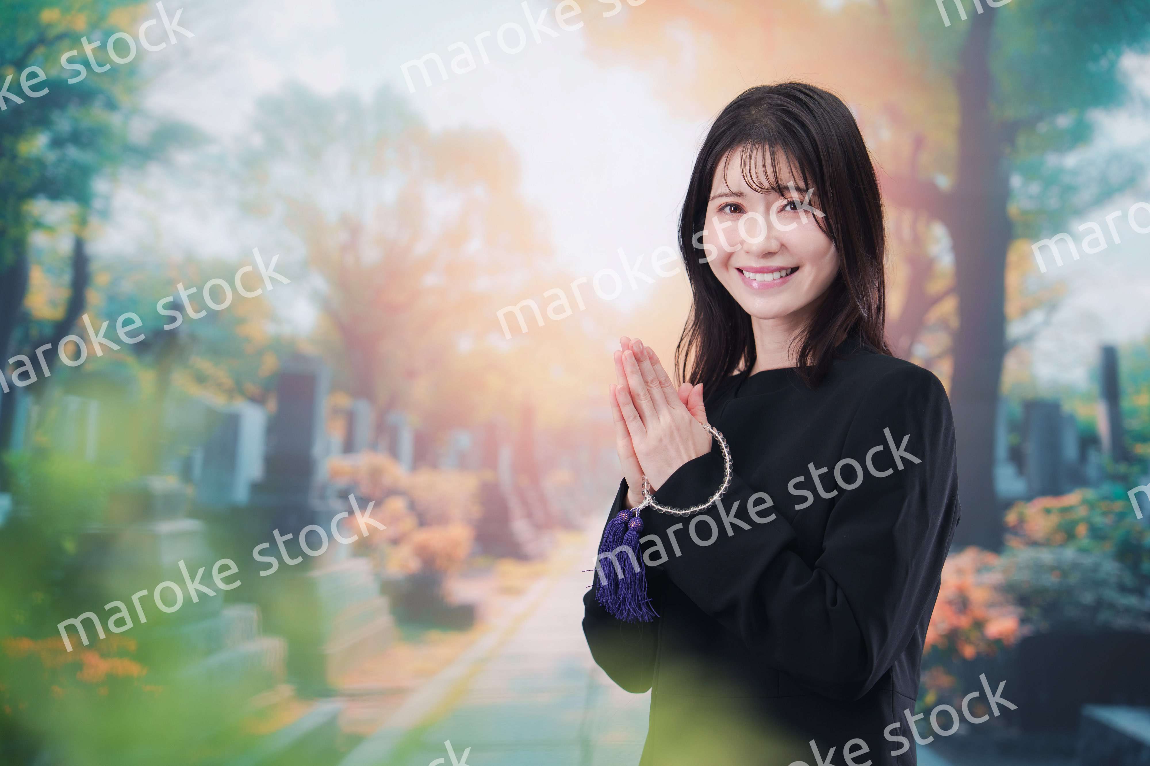 喪服を着てお墓参りをする女性