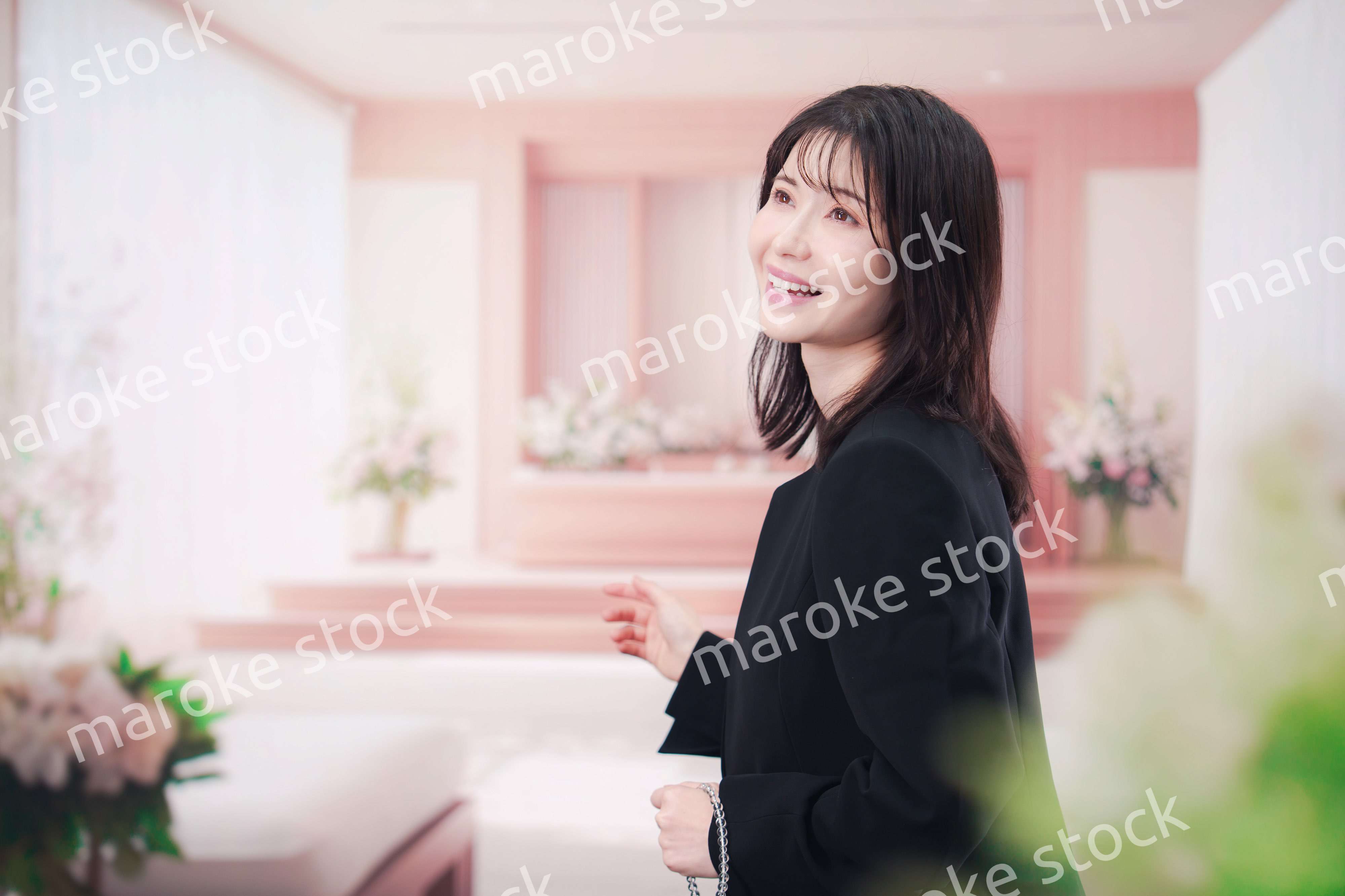 お葬式で喪服を着て数珠を持つ若い女性