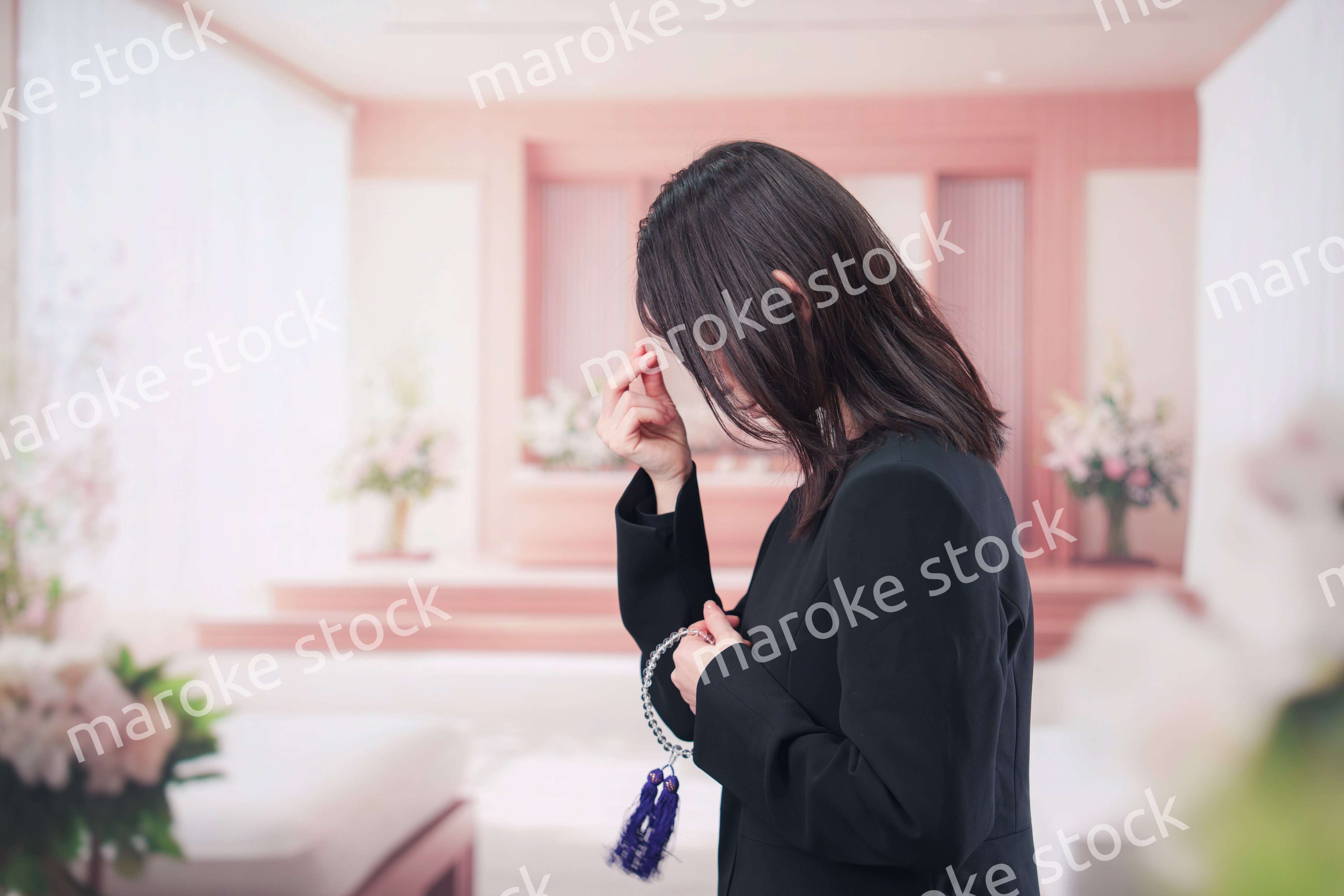 お葬式でお焼香をする女性の参列者