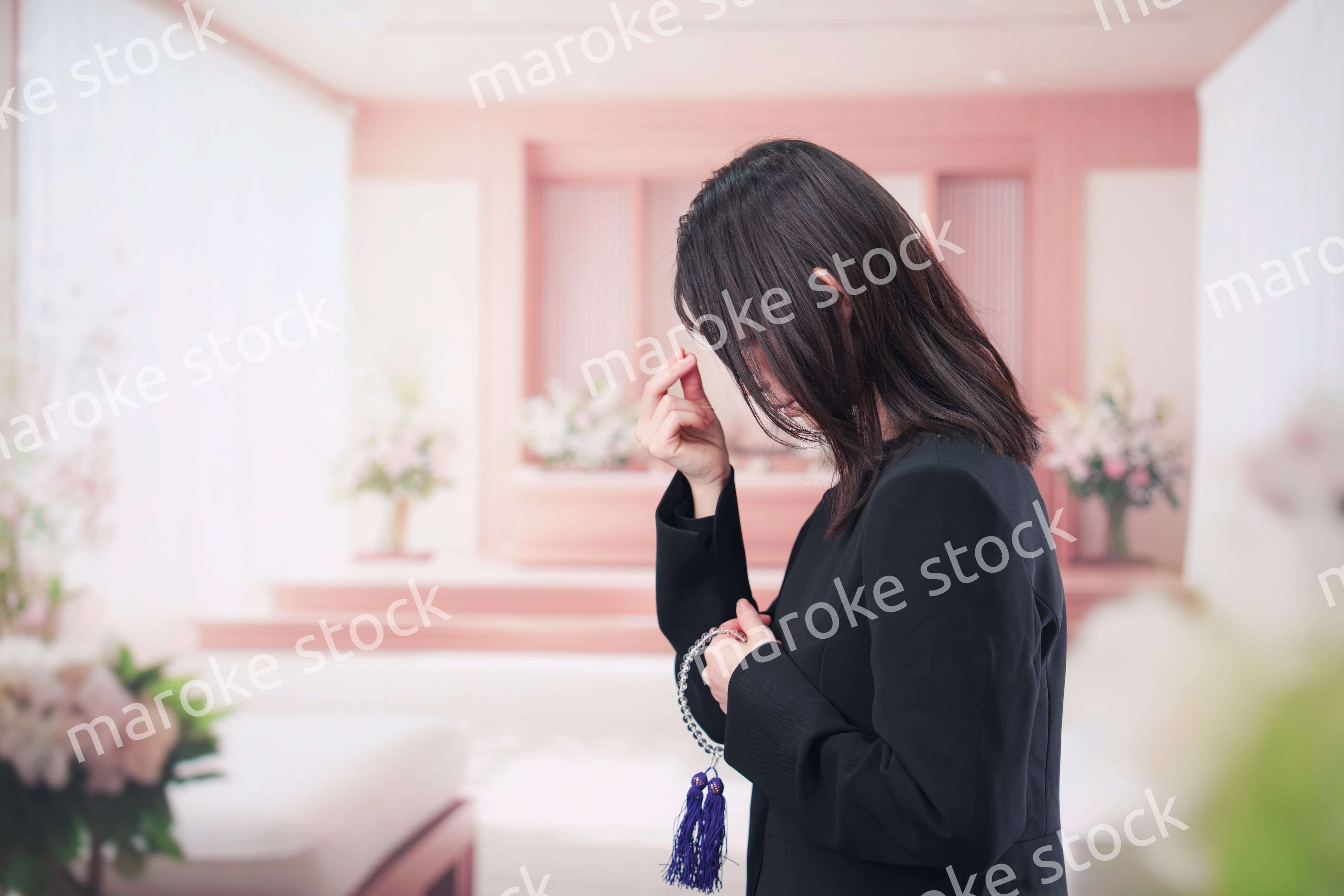 お葬式でお焼香をする女性の参列者