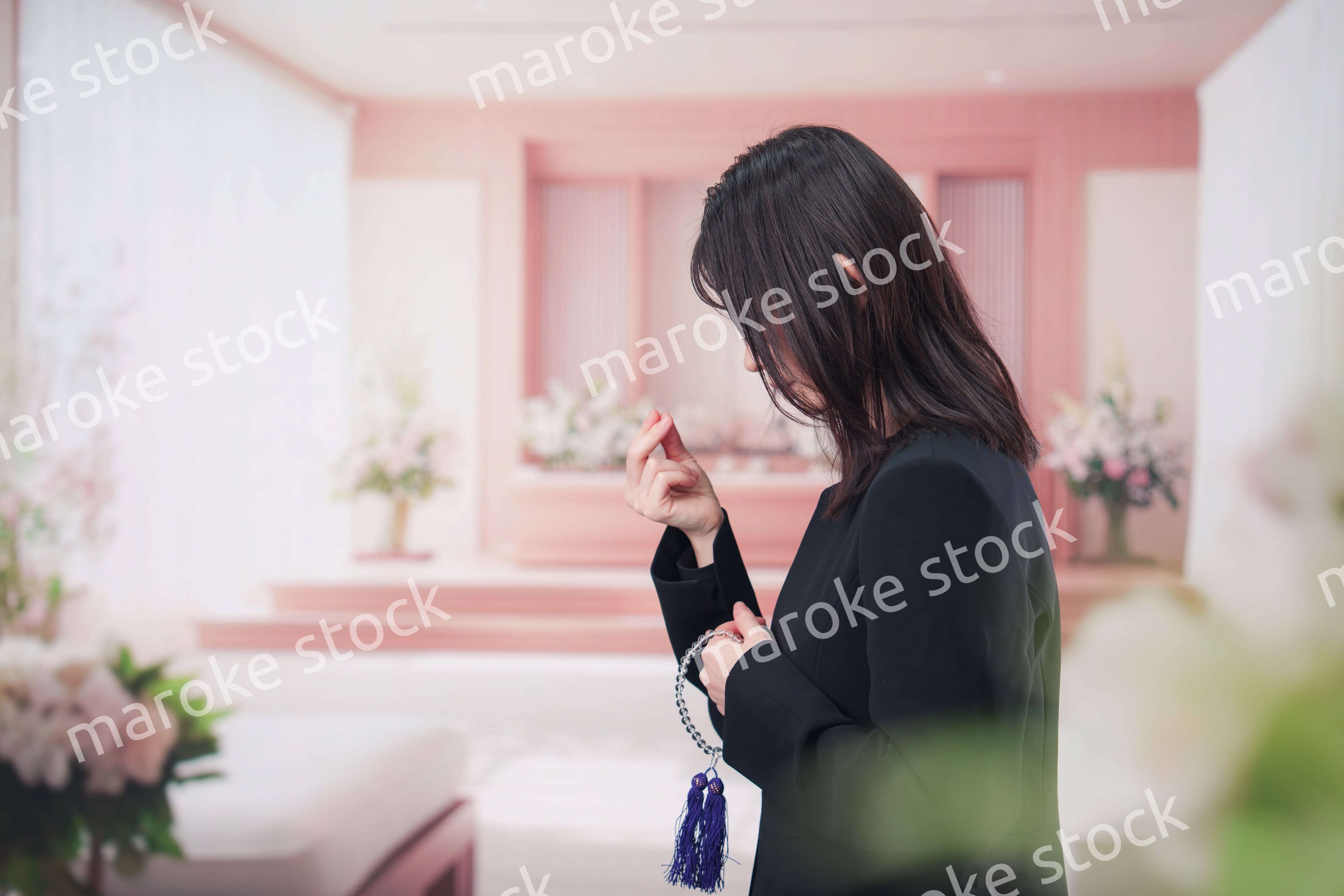 お葬式でお焼香をする女性の参列者