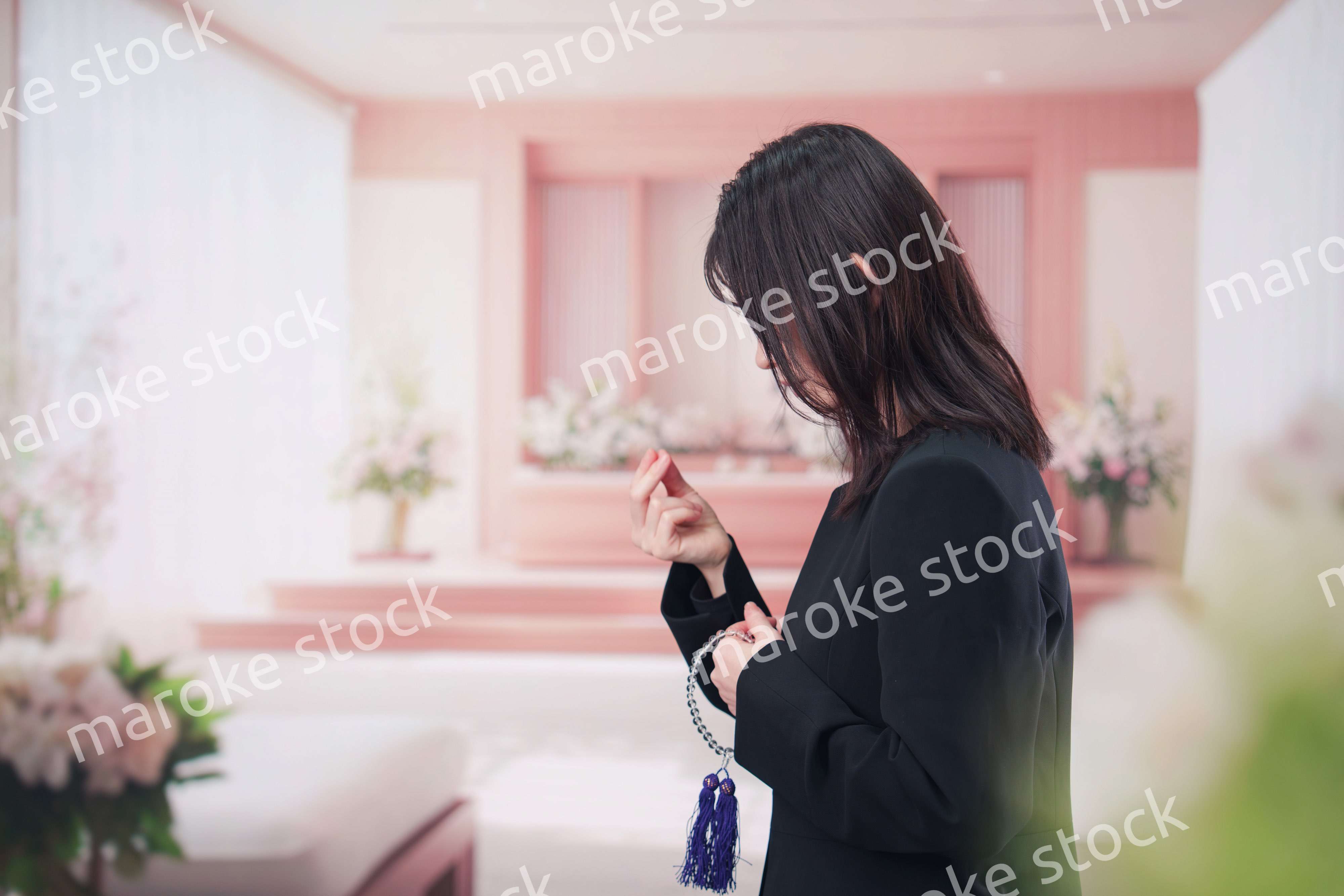 お葬式でお焼香をする女性の参列者