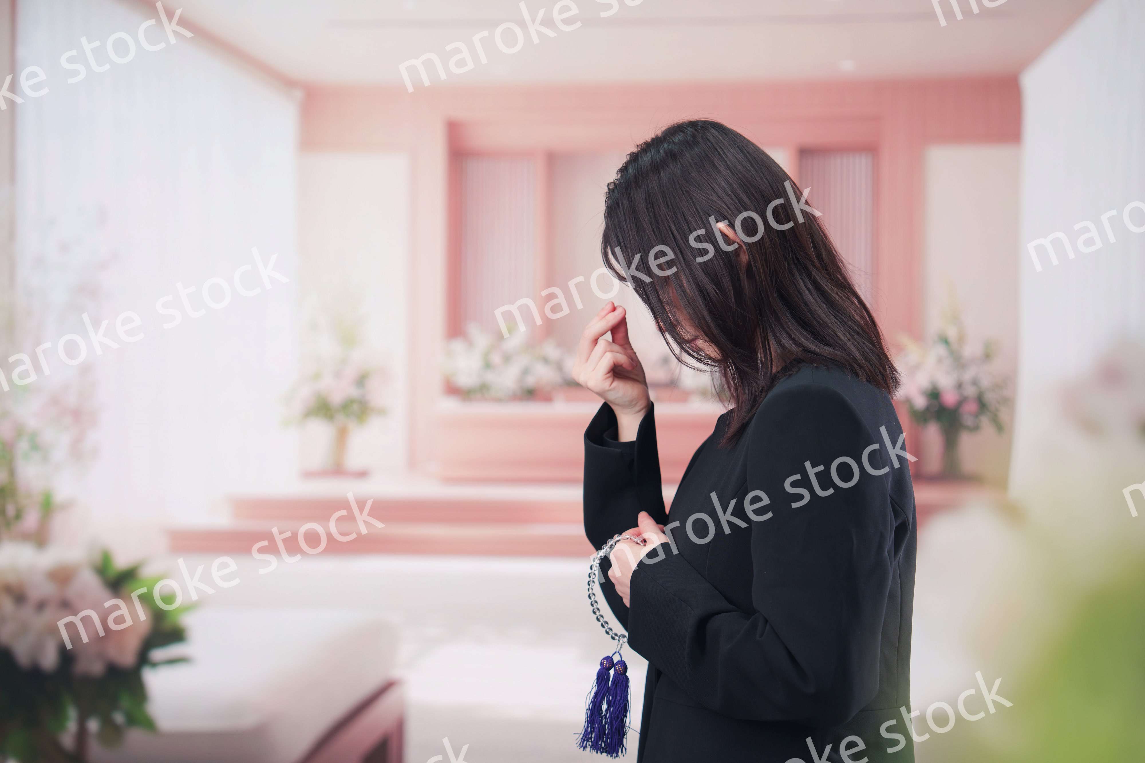 お葬式でお焼香をする女性の参列者