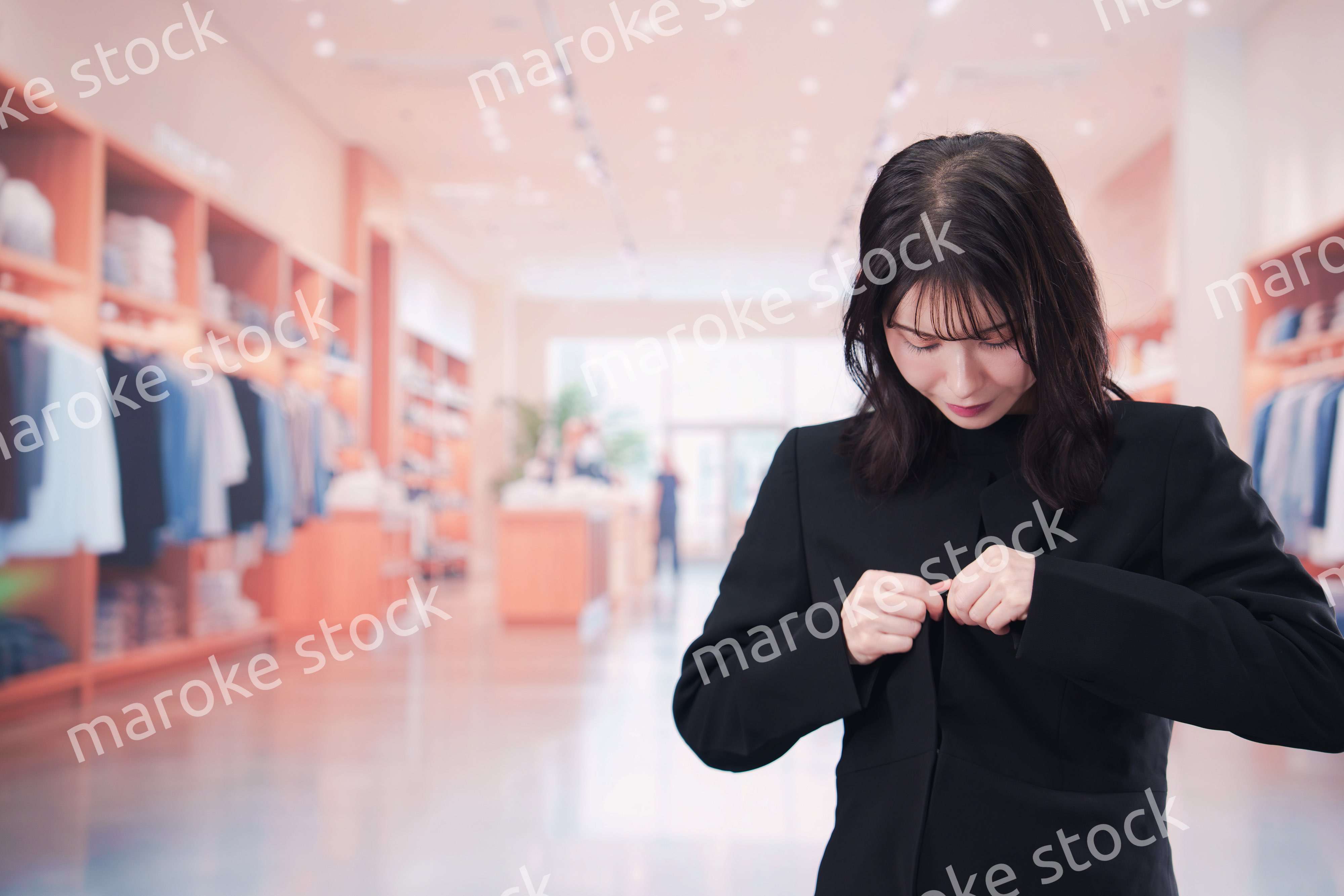 アパレル店で服のフィッティングをする若い女性