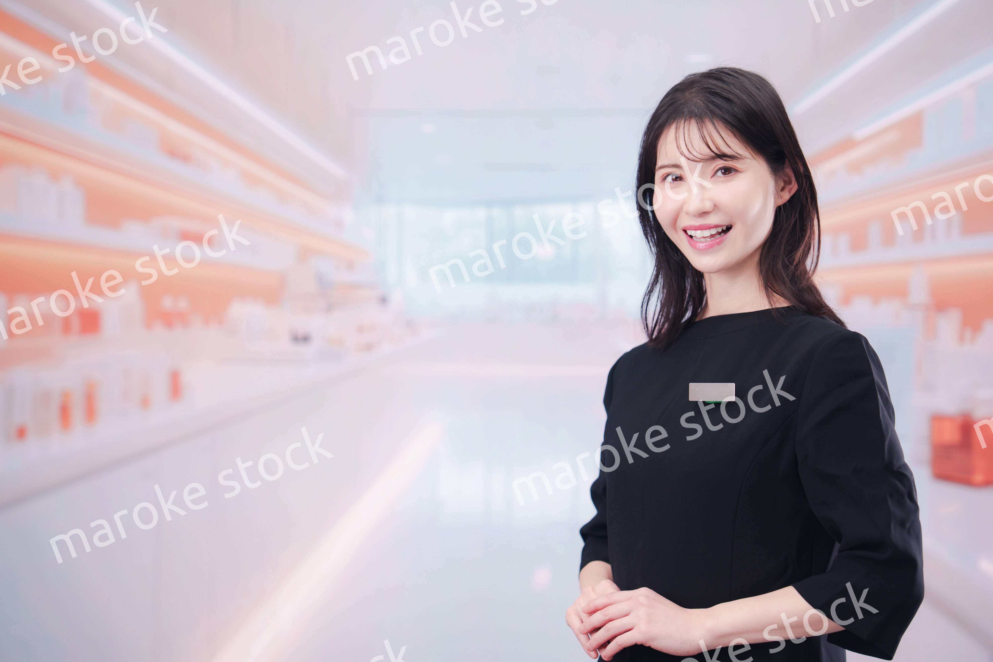 コスメストアで接客をする若い女性店員