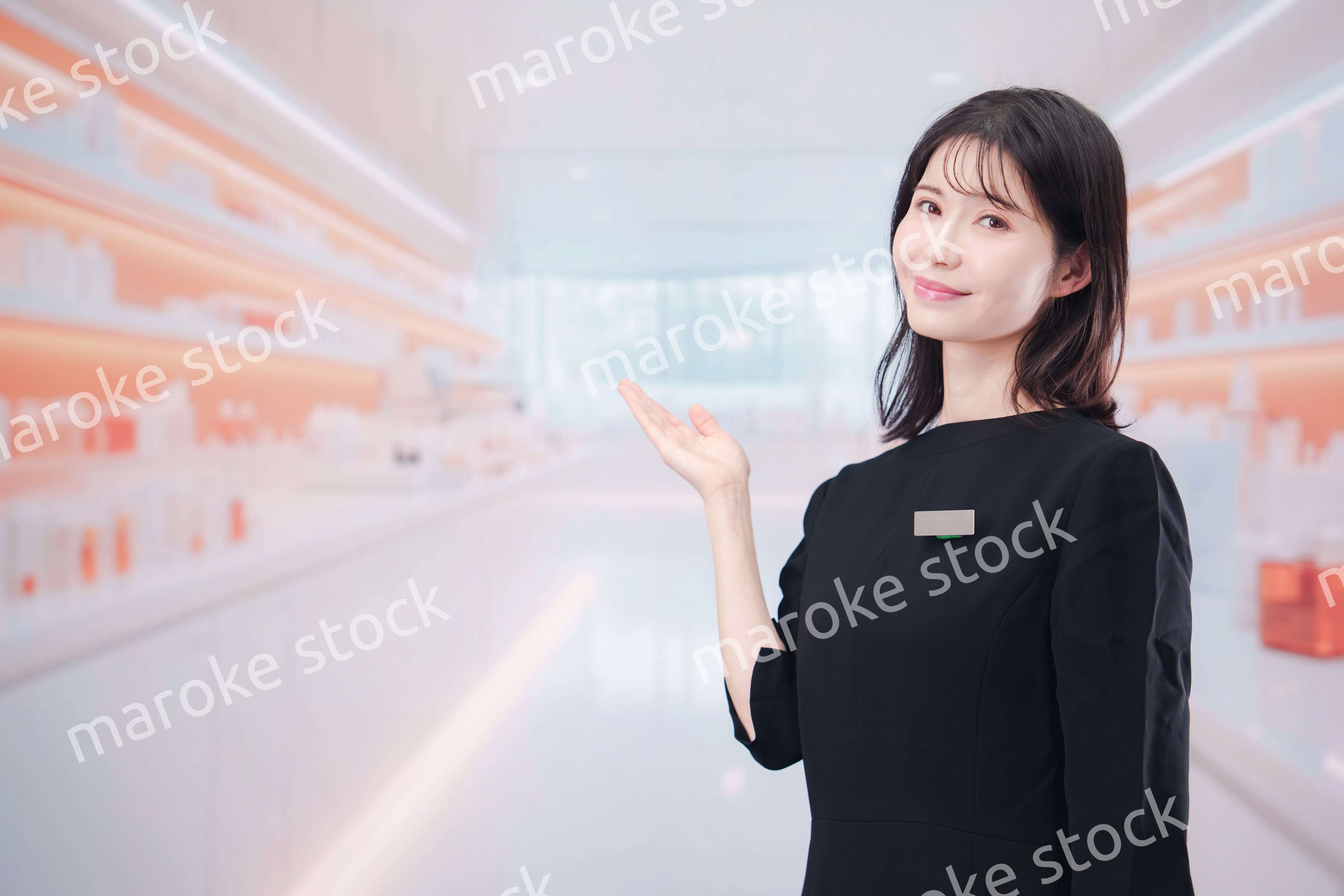 コスメストアで接客をする若い女性店員