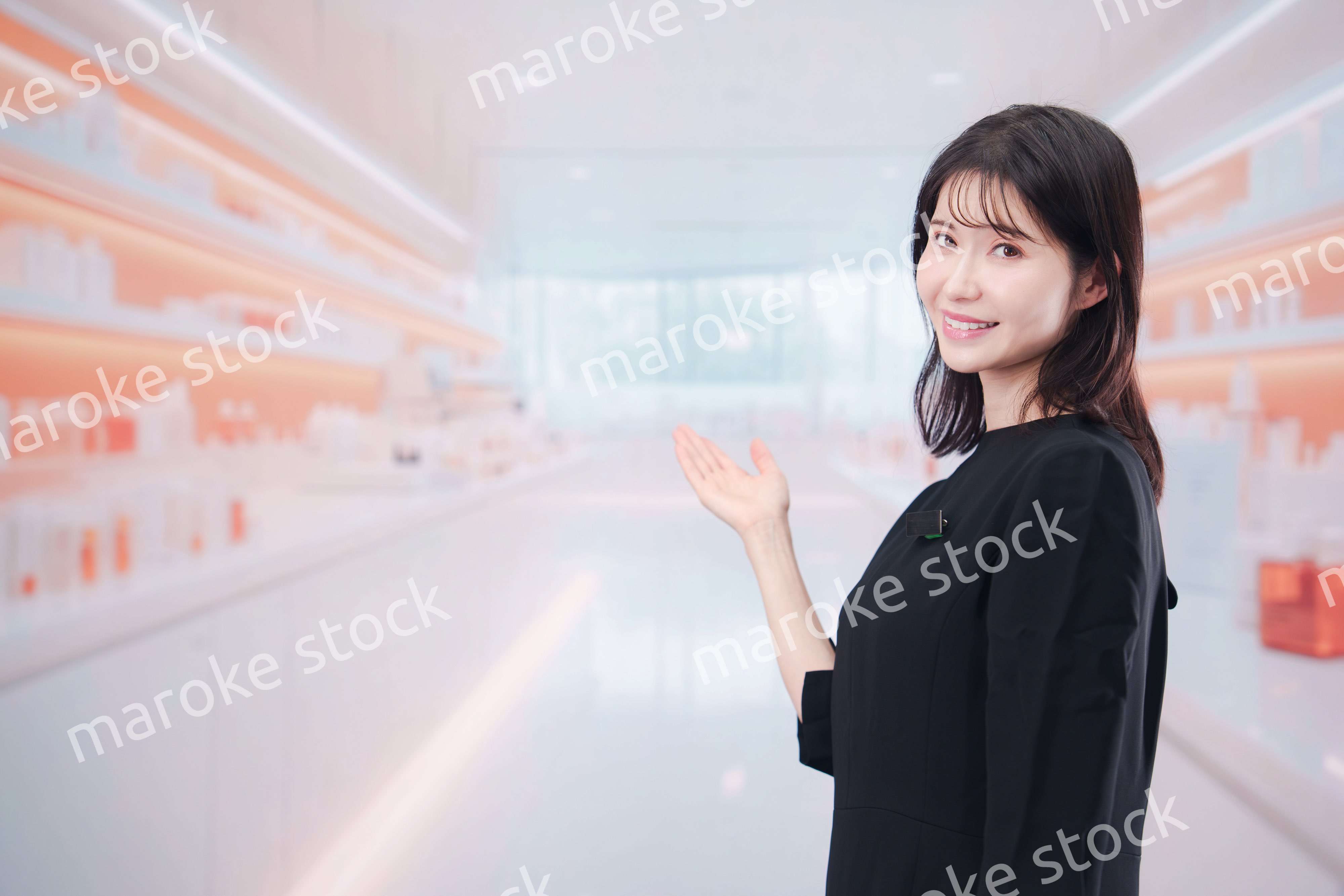 コスメストアで接客をする若い女性店員