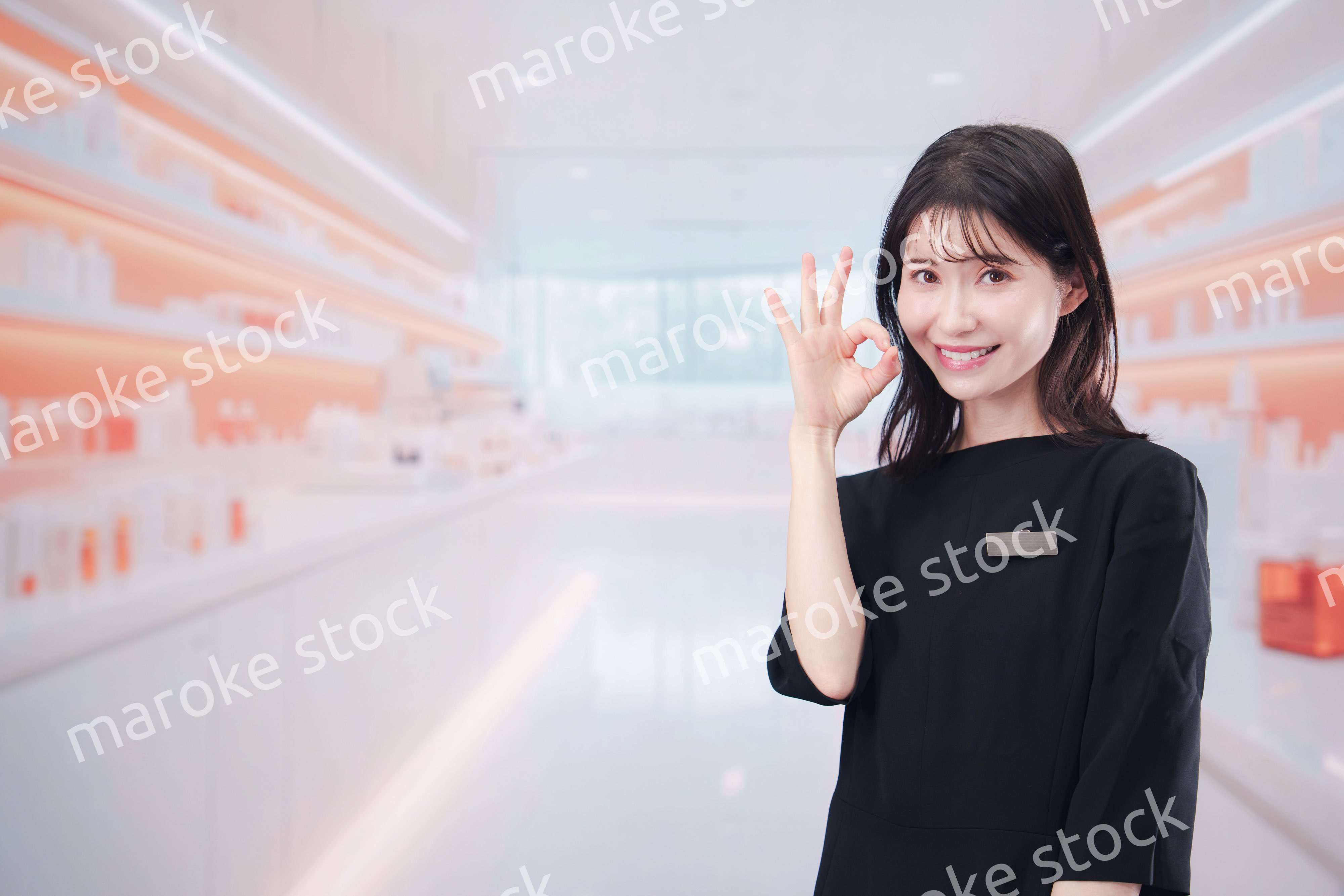 コスメストアで接客をする若い女性店員