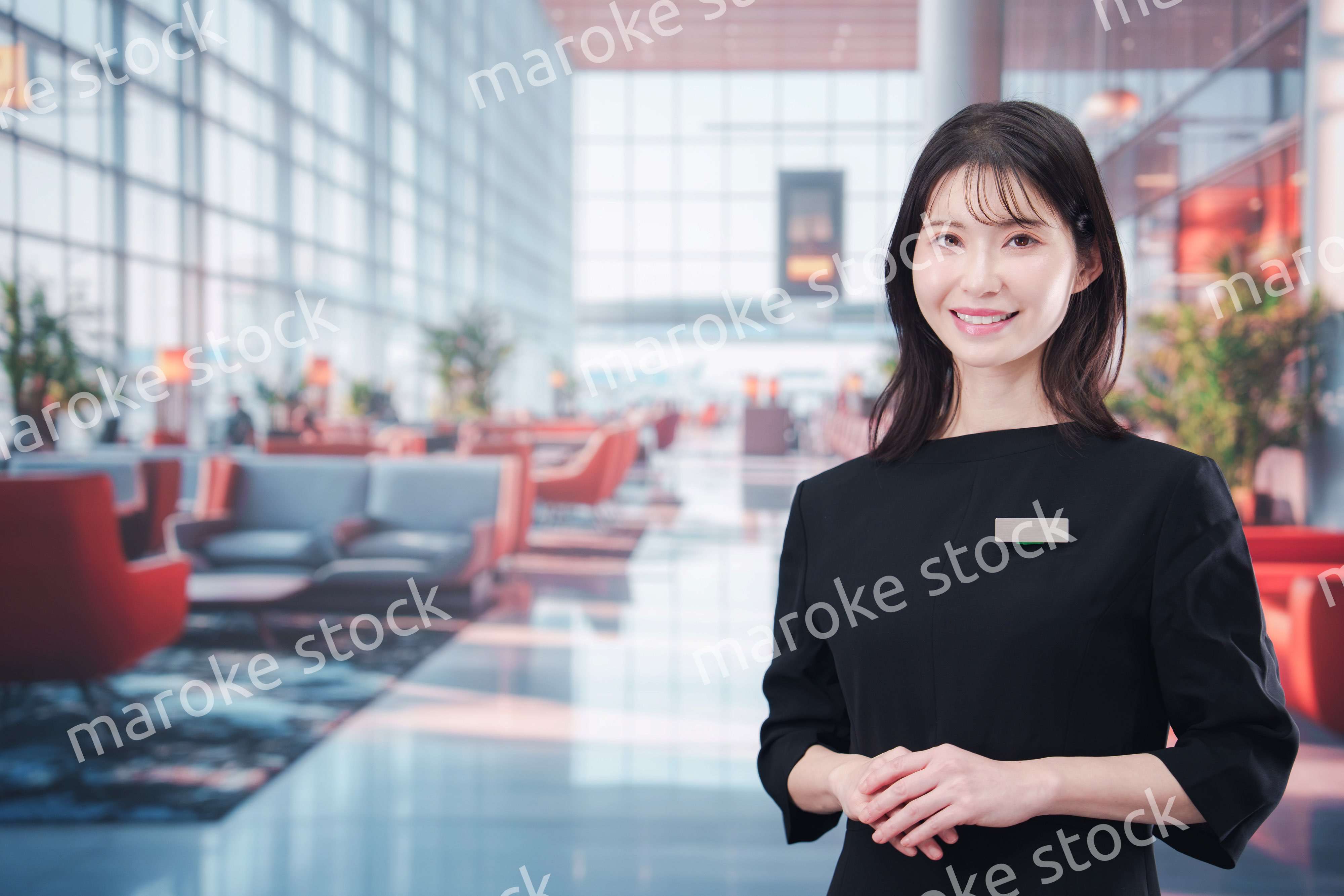 空港のラウンジで接客をする若い女性スタッフ