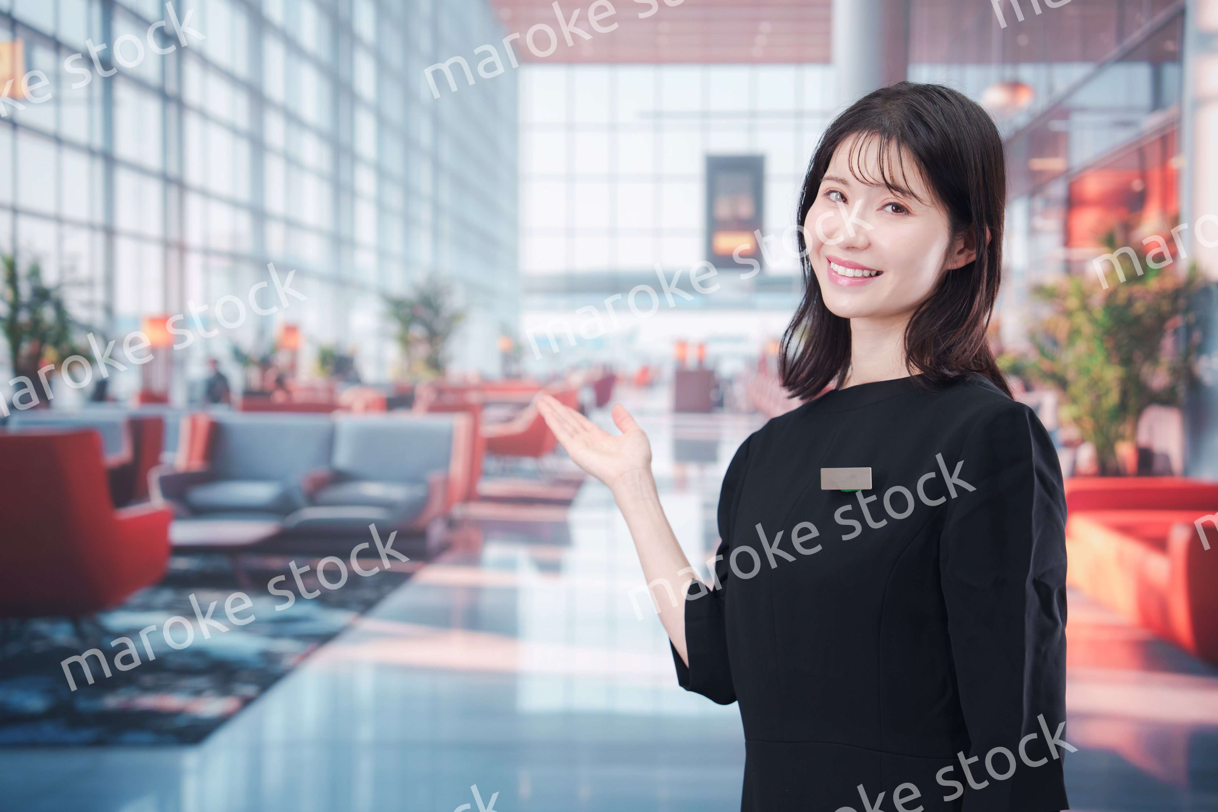 空港のラウンジで接客をする若い女性スタッフ