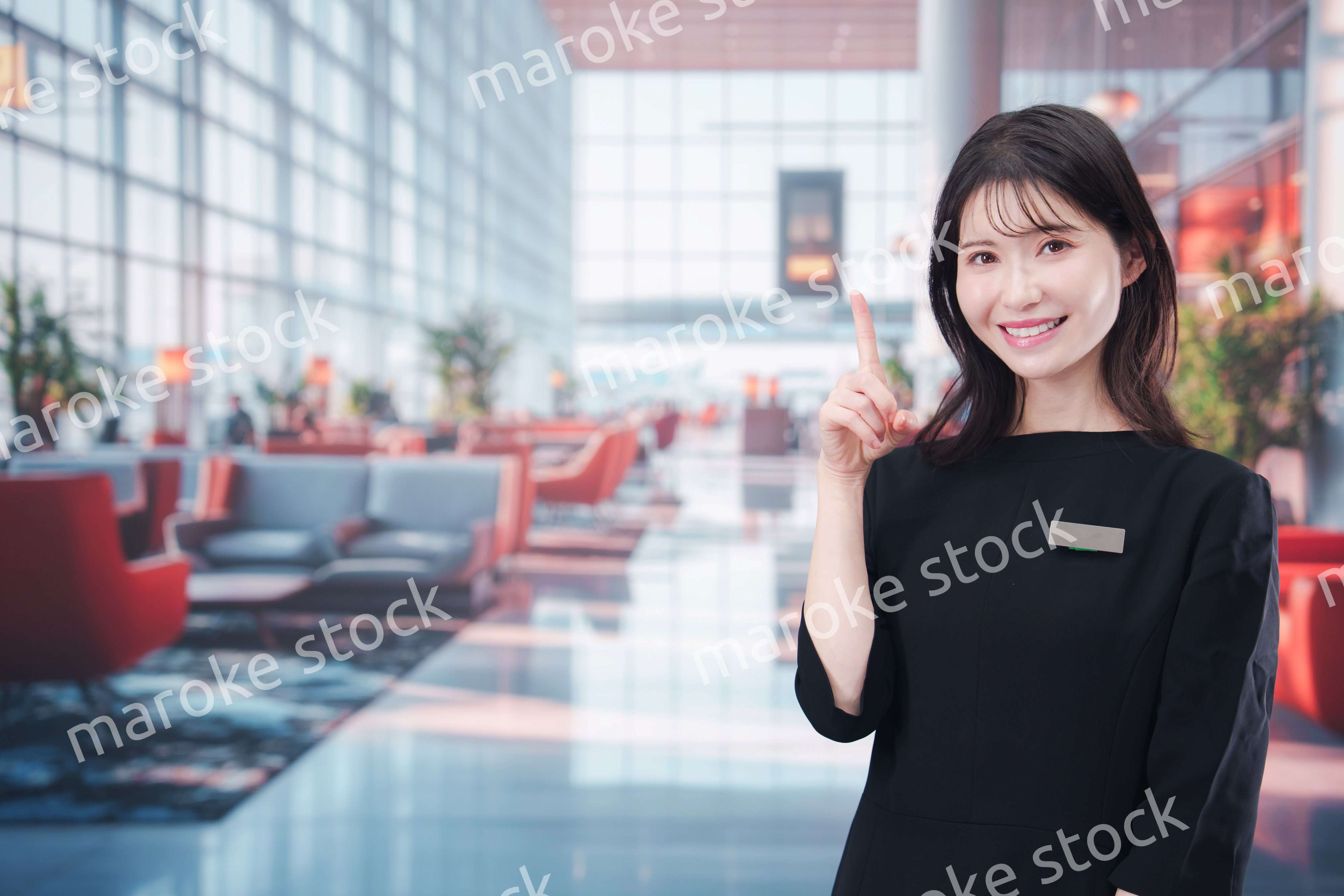 空港のラウンジで接客をする若い女性スタッフ