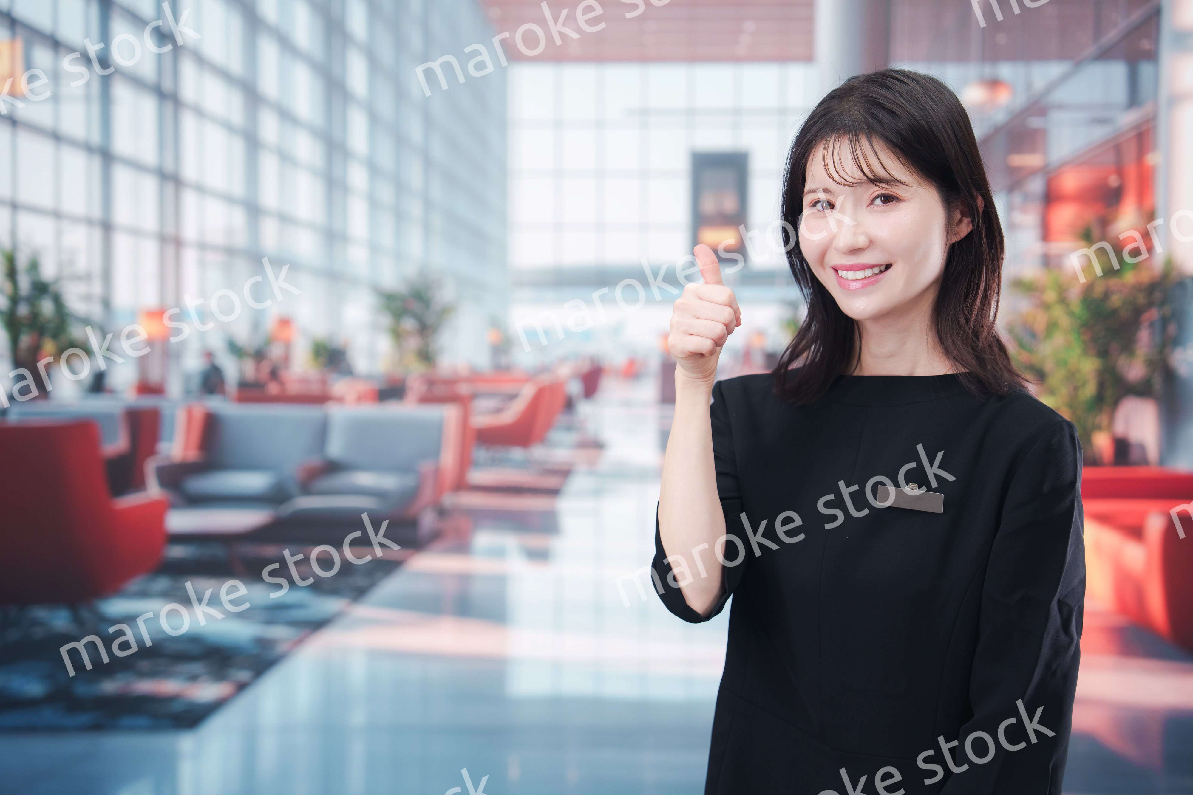 空港のラウンジで接客をする若い女性スタッフ