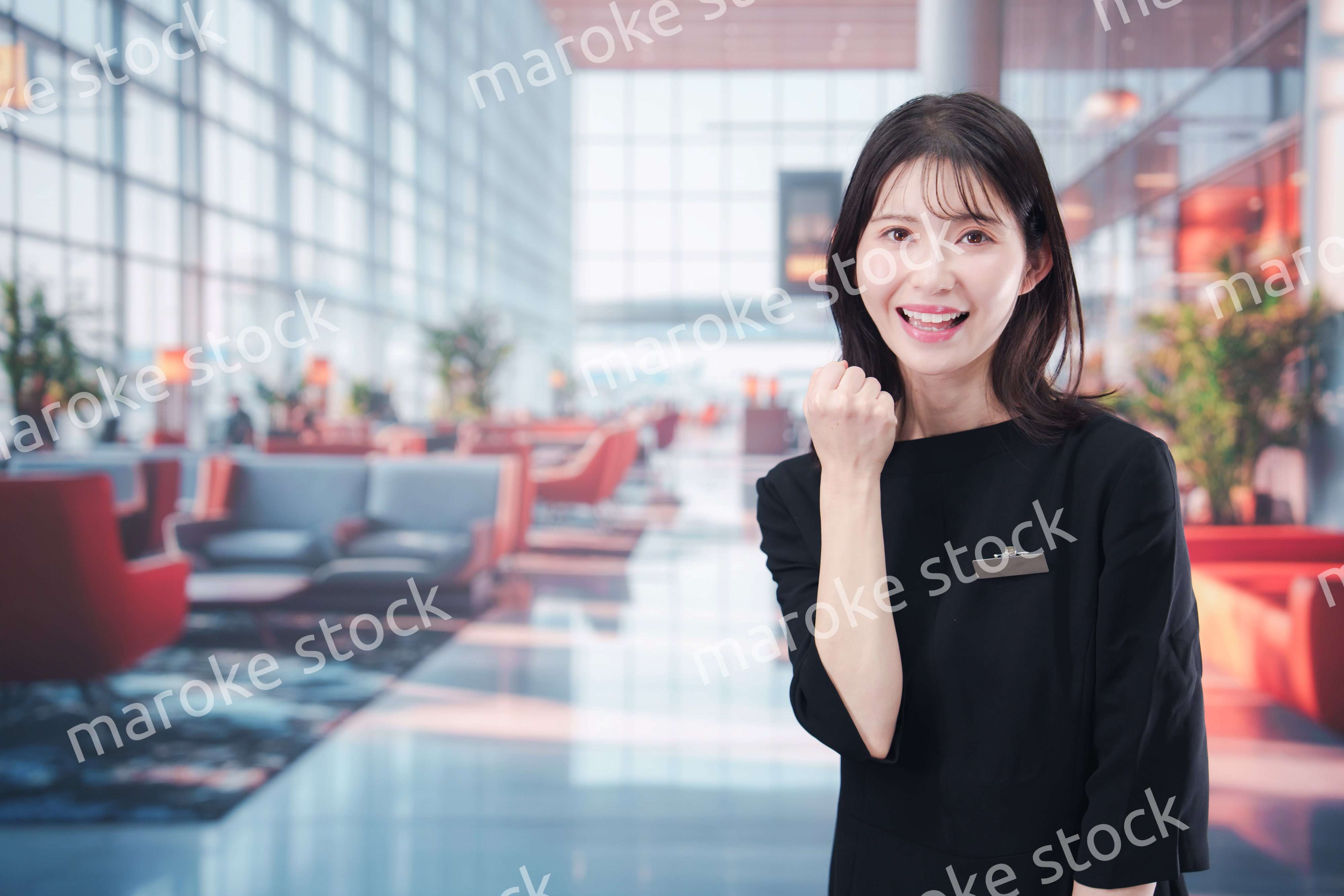 空港のラウンジで接客をする若い女性スタッフ