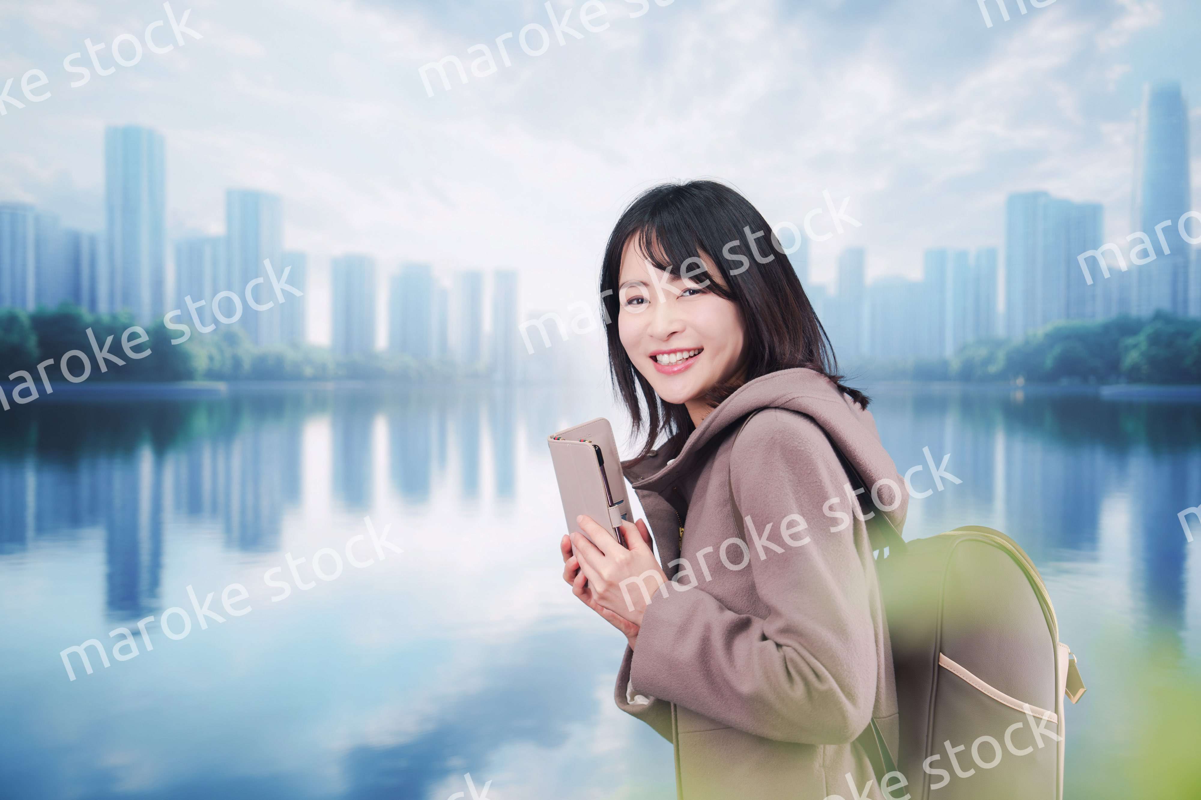 コートを着てスマホを使いながら外を歩く若い女性