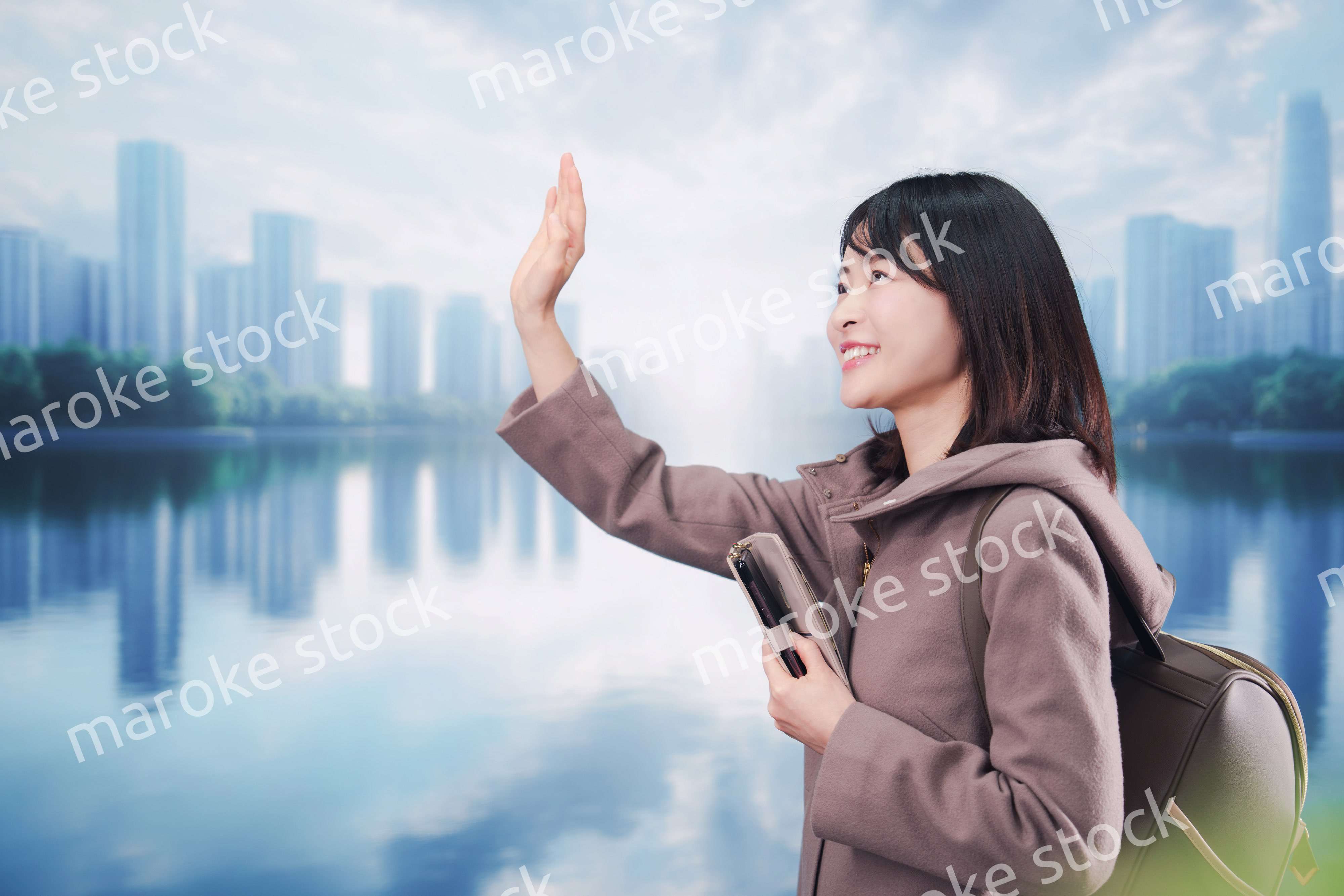 コートを着てスマホを使いながら外を歩く若い女性